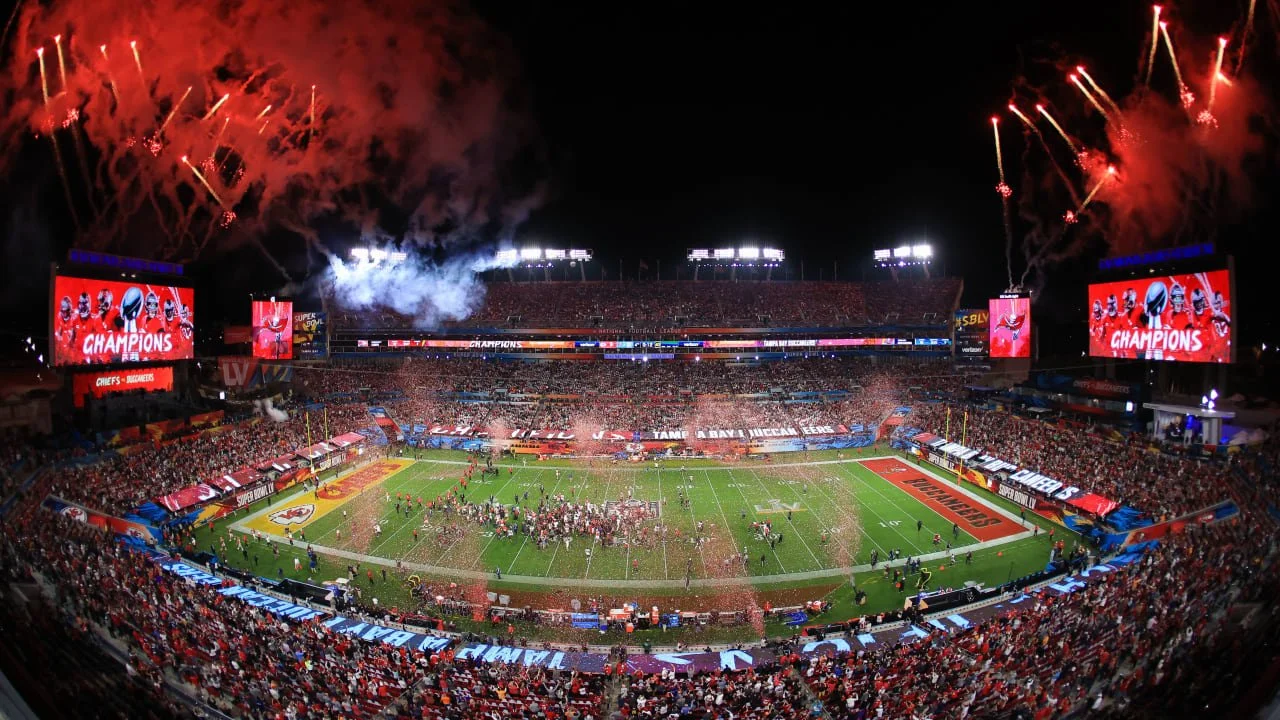 Kansas City Chiefs celebrating victory with fireworks and crowd in a football stadium at night.