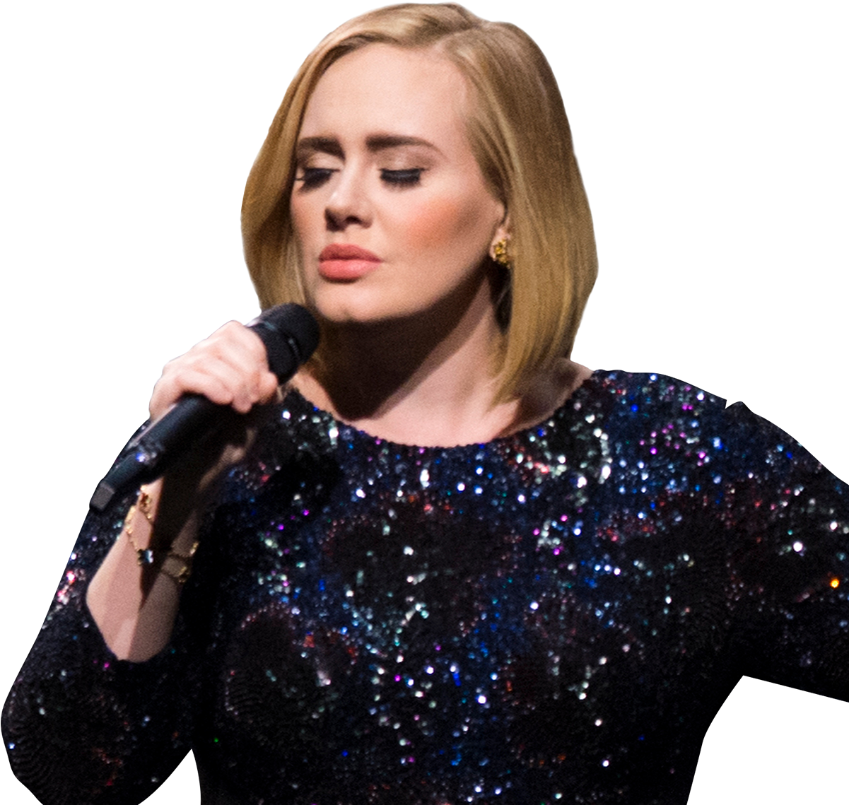 A woman with blonde hair singing into a microphone, wearing a dark, sequined dress.