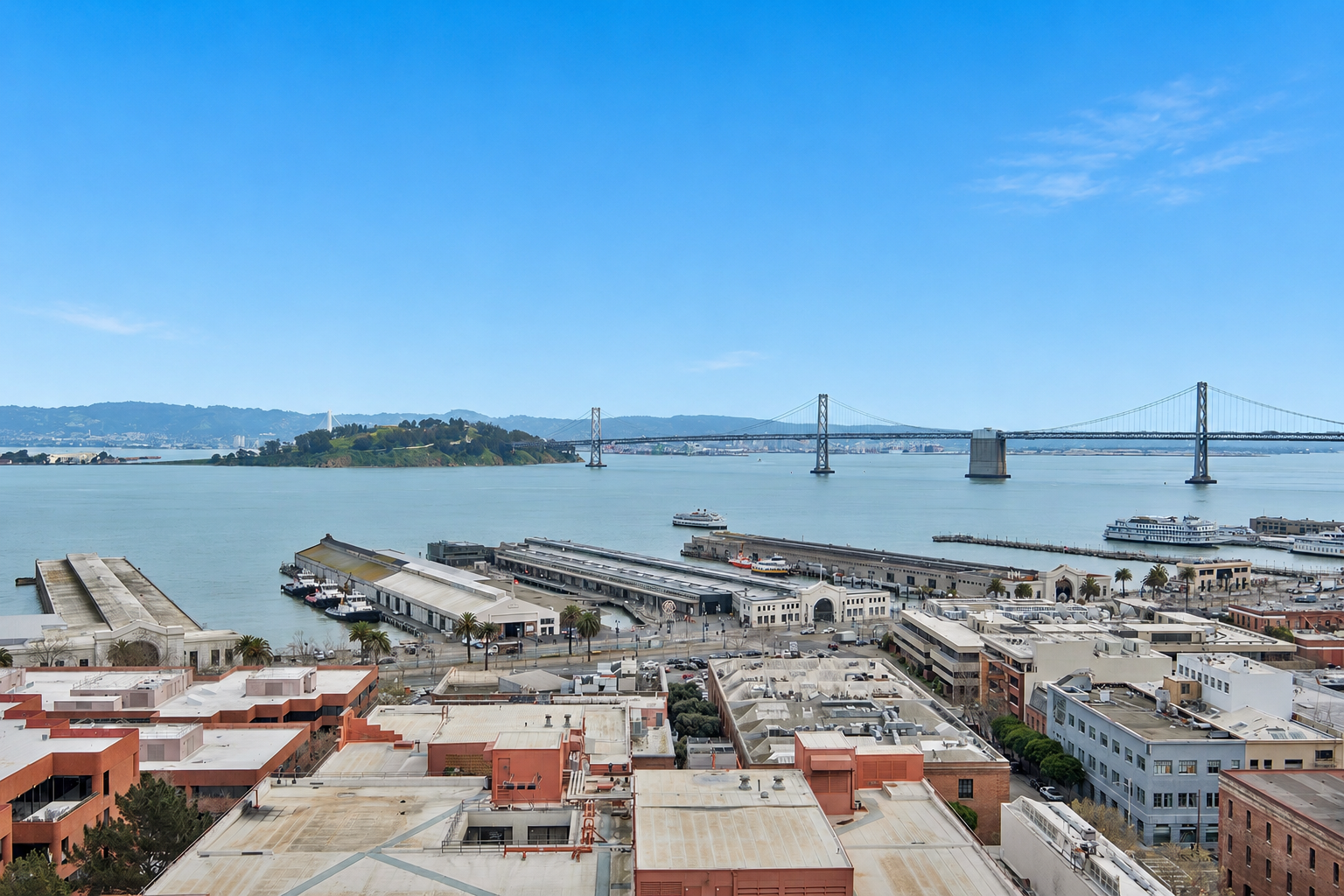 Skyline of San Francisco with bay, docking stations, boats, and the Bay Bridge in the background.