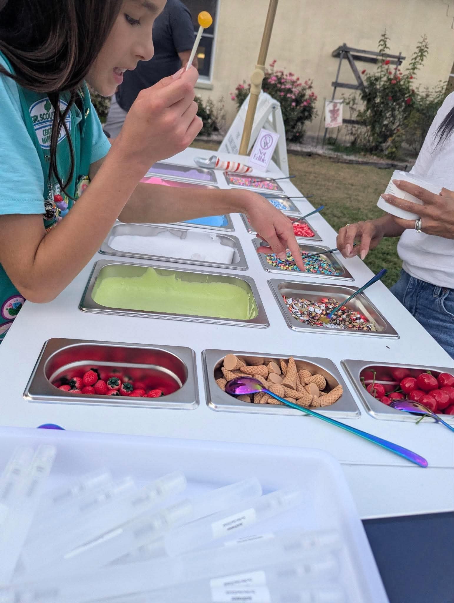 
A Child selecting slime and toppings at an event.