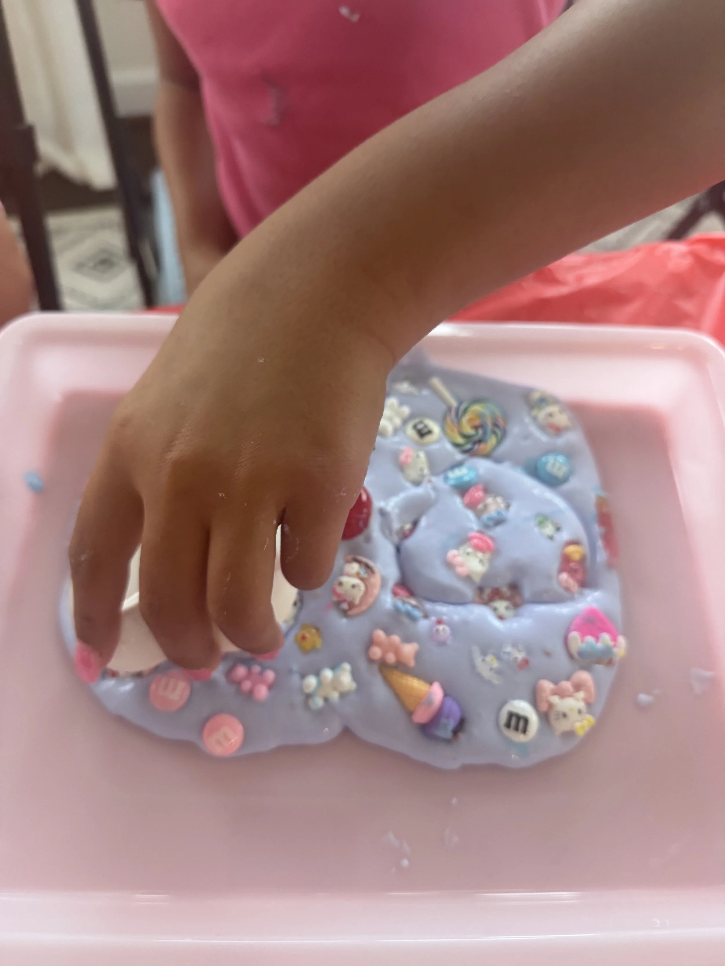 A child playing with a colorful slime creation.