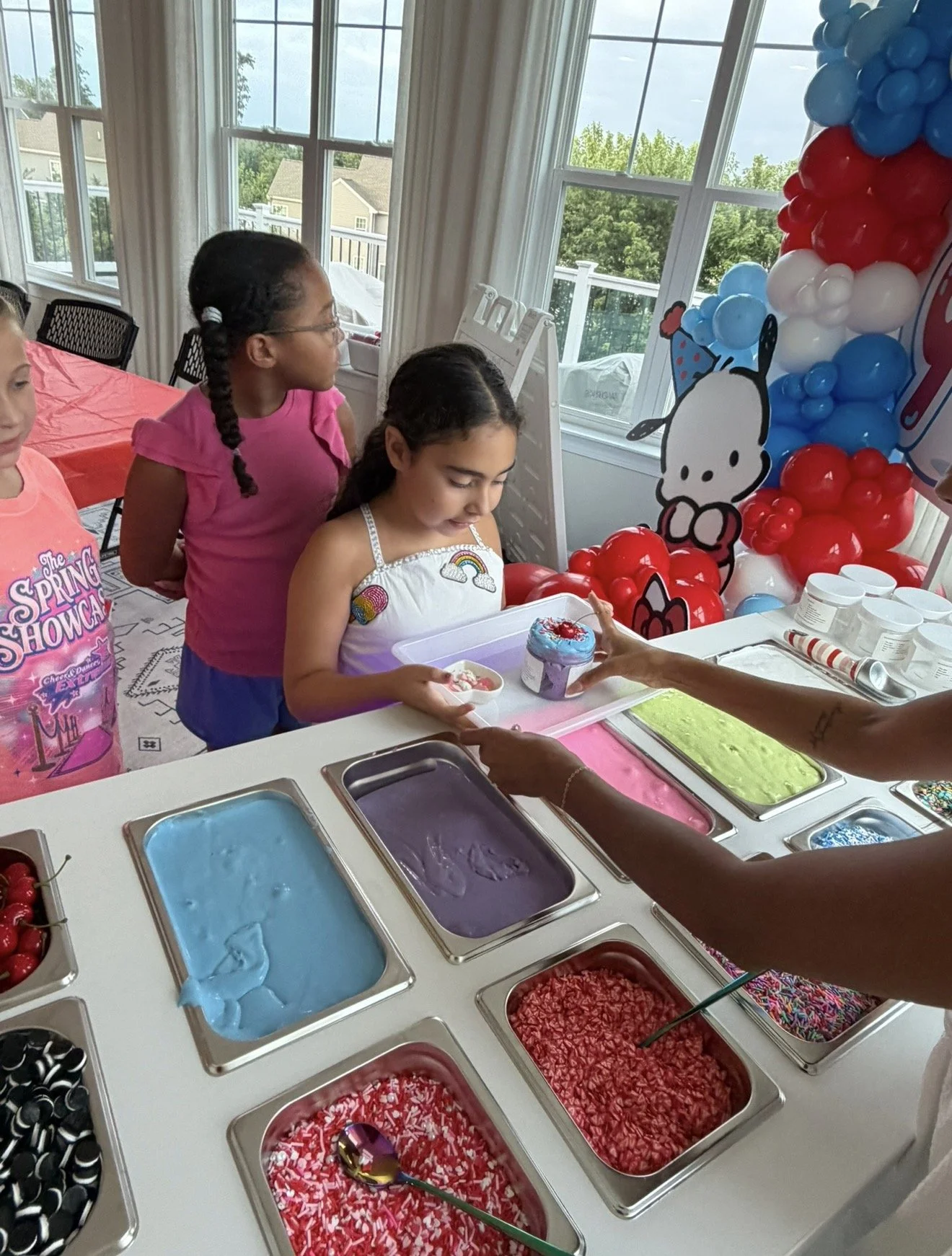 Children creating slime together at a slime station.