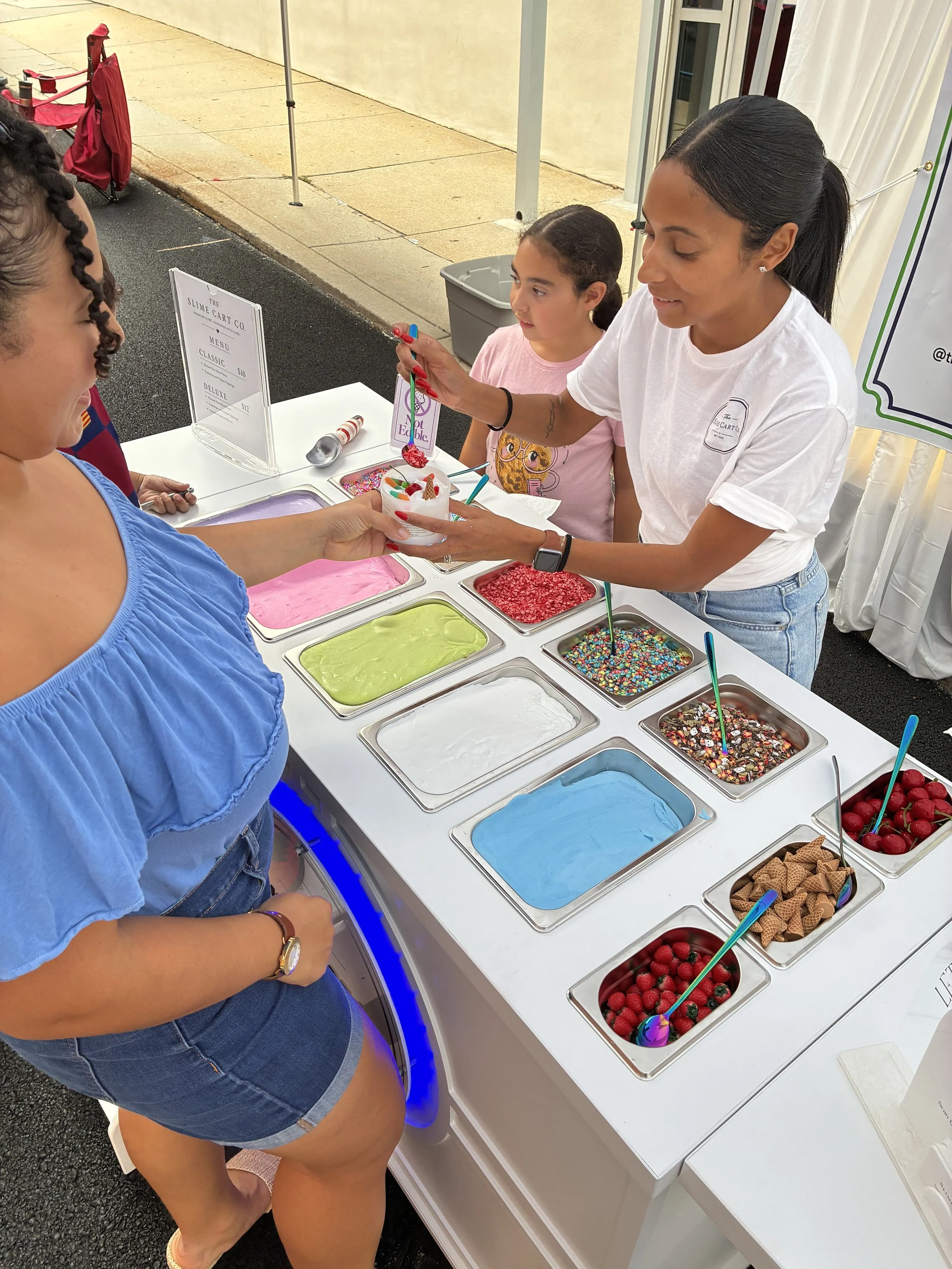 a women creating slime at The Slime Cart Co. station at an event