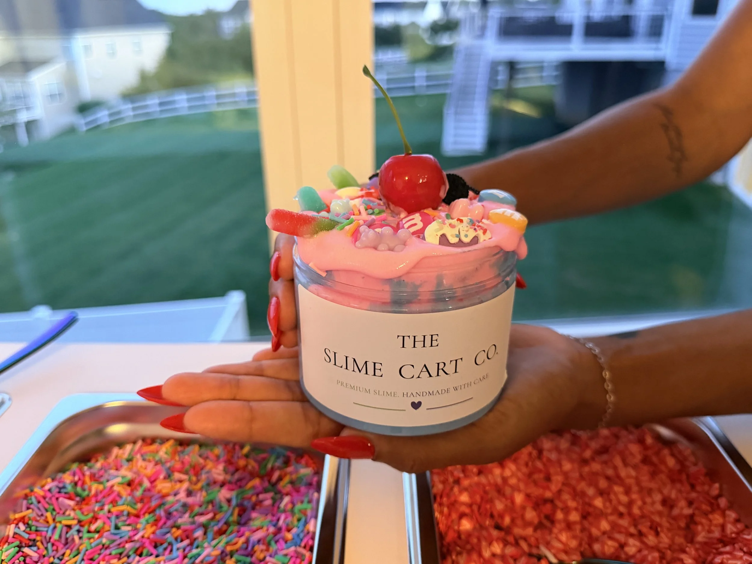 An adult hand holding a custom slime creation.