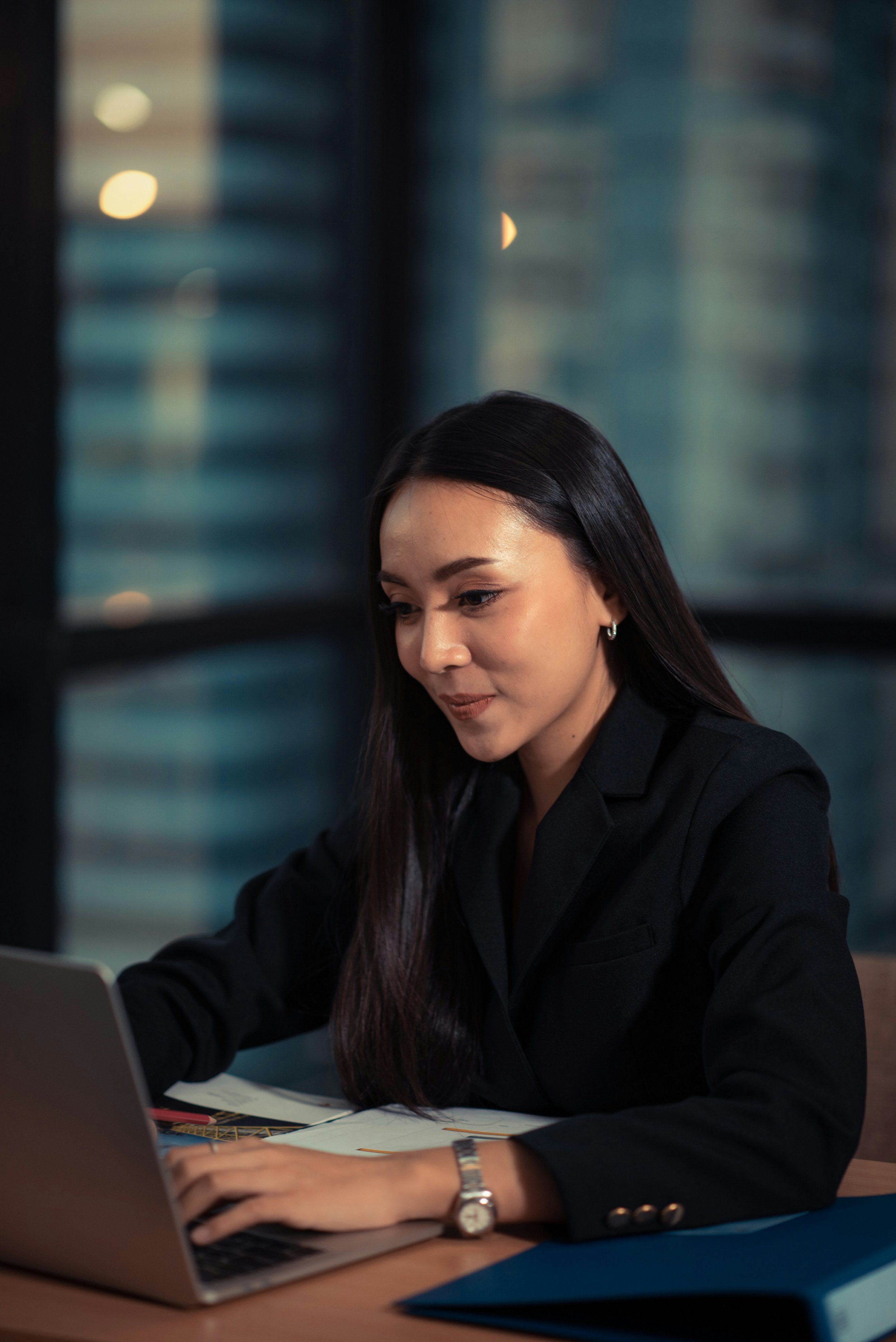 Online therapist in California - a photo of a woman with black hair wearing a business suit in front of her laptop