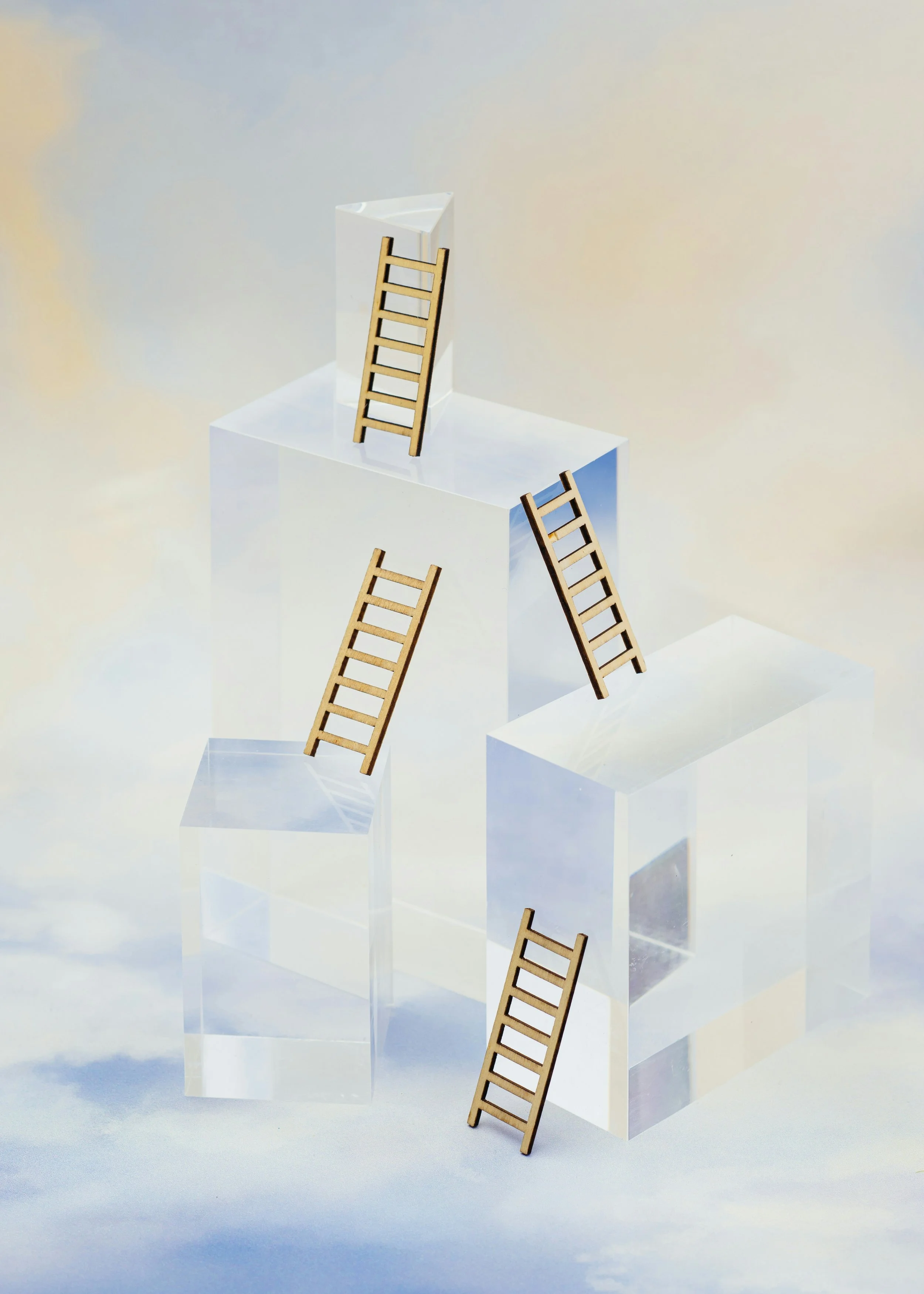 Online therapy for high achievers - an abstract photos with ladders stacked on top of clear cubes to represent ambition and drive for high achievers in therapy