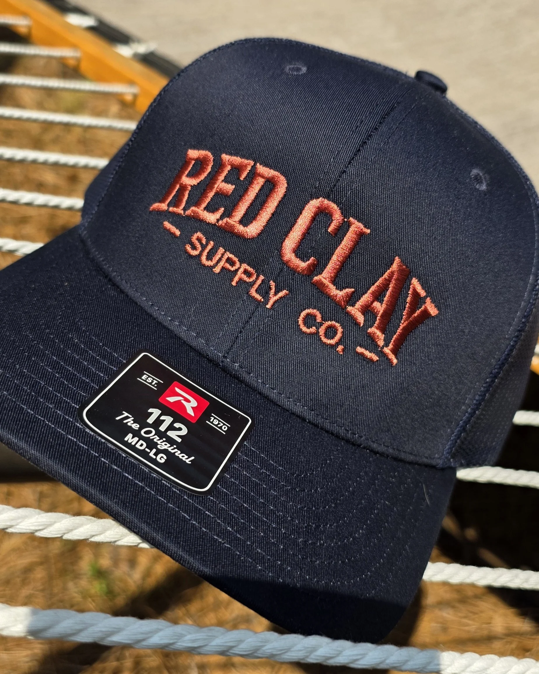 Close-up of a navy blue Red Circle supply cap with embroidered red text