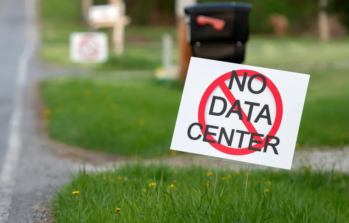 Sign on a lawn with the words 'No Data Center' crossed out in red.