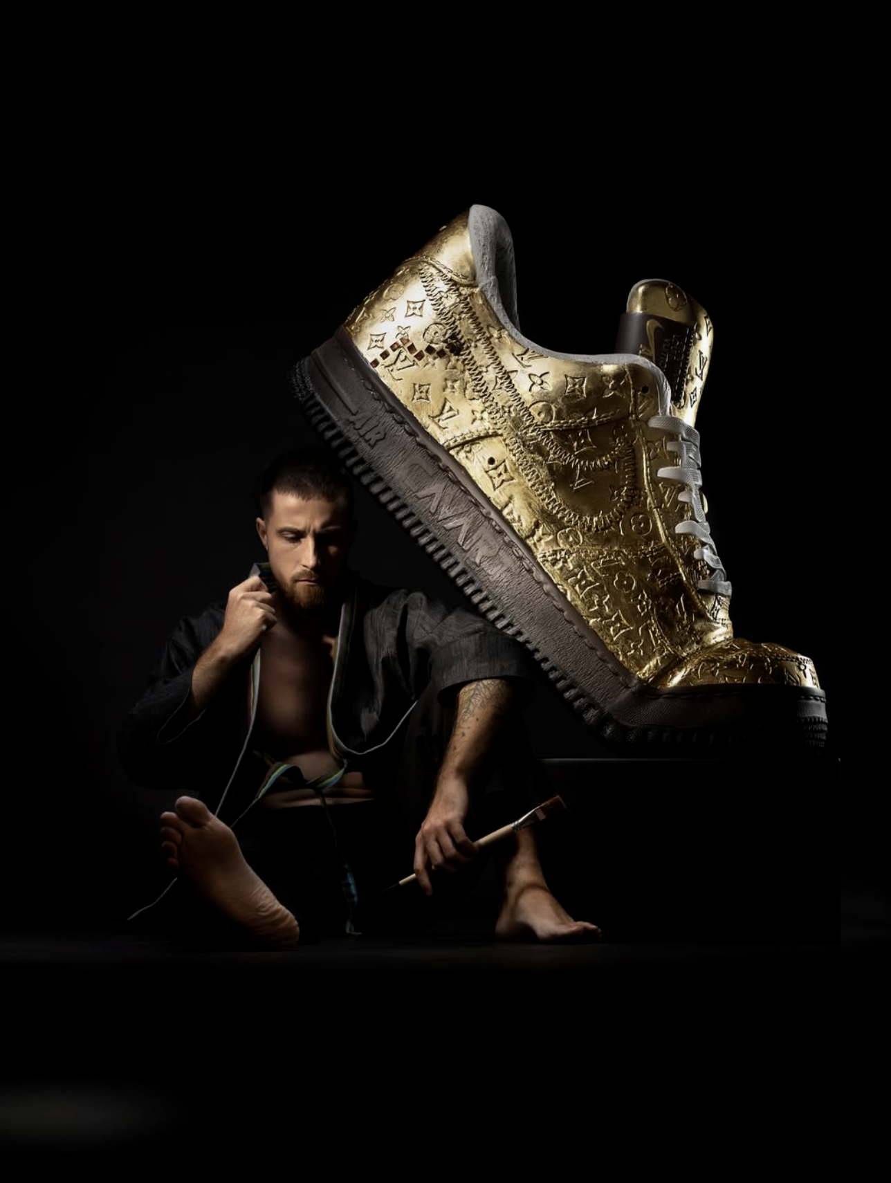 Julian Cavaillé in a martial arts pose with a large, gold, decorated sneaker in the background.