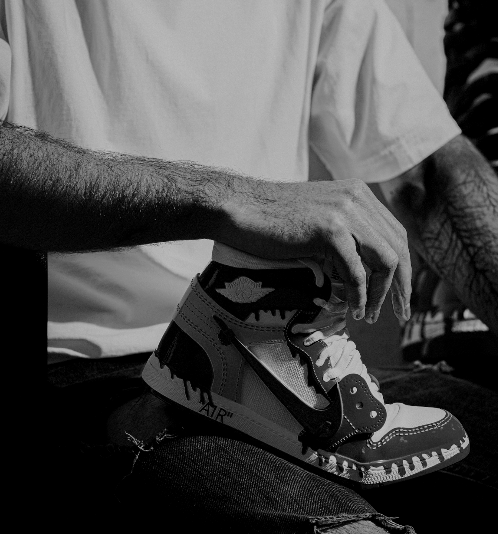 Julian Cavaillé tying their Nike Air Jordan sneakers.