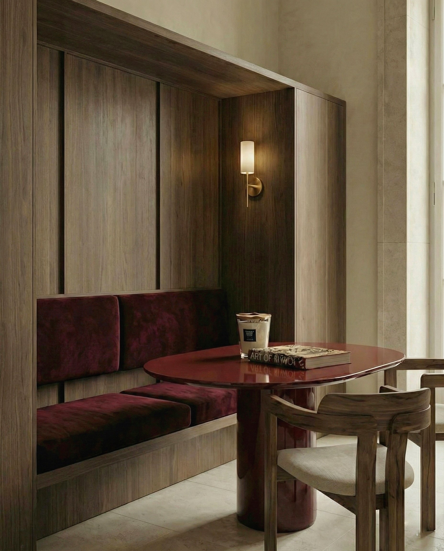 Een zithoek met een ronde tafel, een beige stoel, een muurlamp en een wandkast, in een interieur met houten panelen en vloeren.