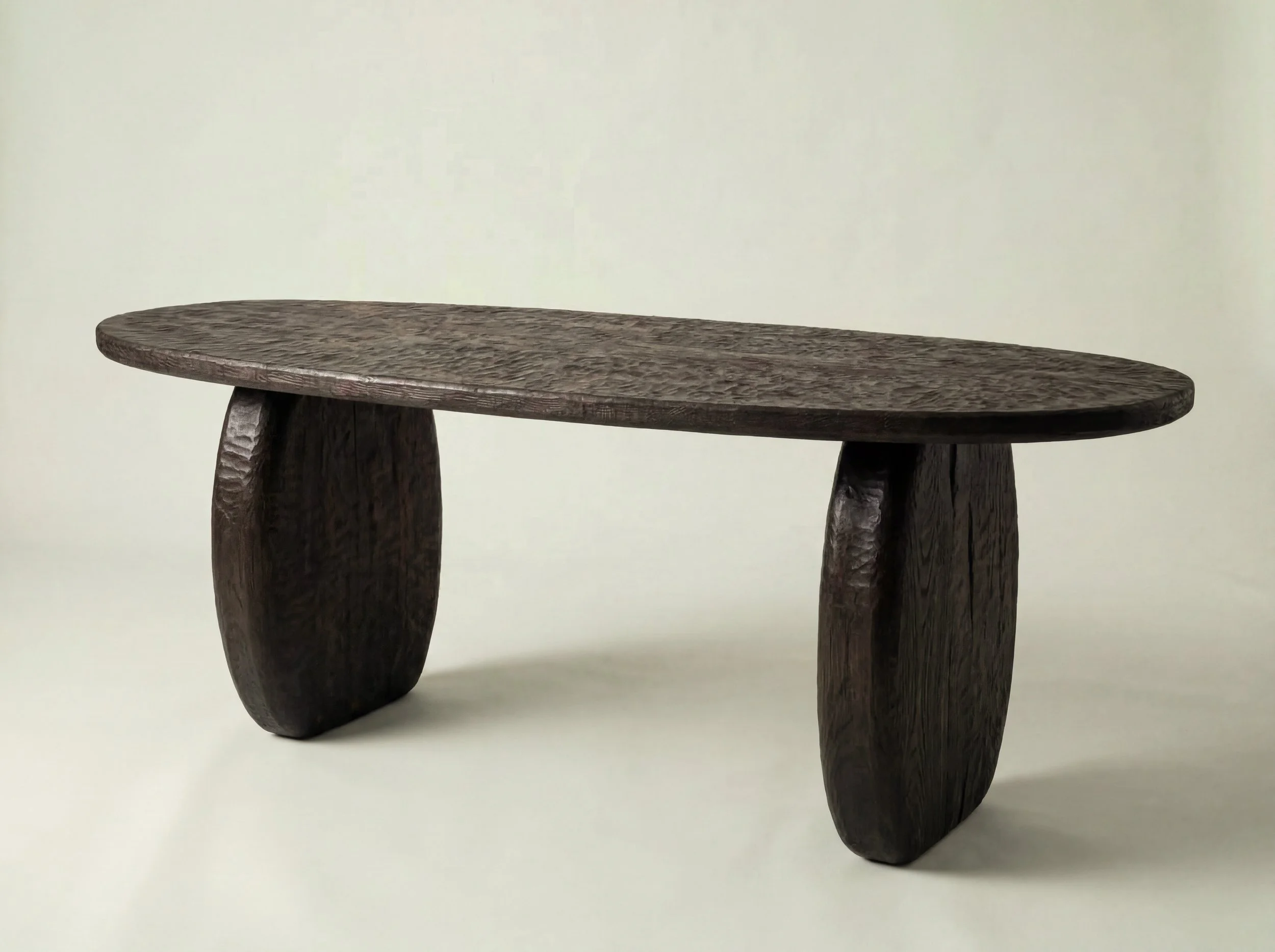 Een minimalistisch houten tafeltje met een ruwe textuur en een natuurlijke houtkleur, geplaatst tegen een effen witte achtergrond.