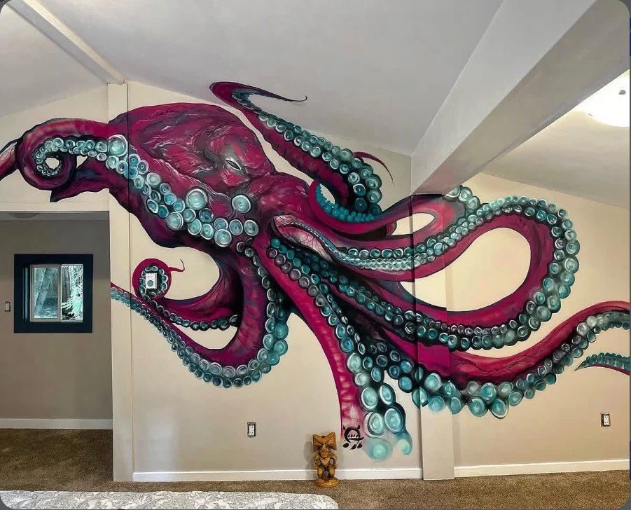 A colorful mural of a large pink and purple octopus with turquoise-tipped tentacles painted on a living room wall.