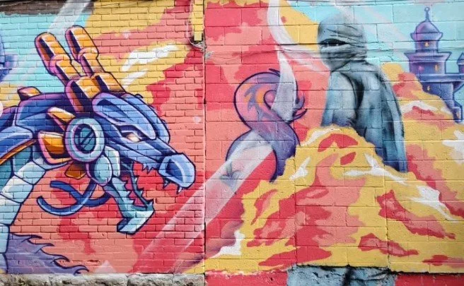 Colorful graffiti mural on brick wall depicting a dragon, a list, and a person wearing a hat with a cityscape in the background. Art, street art, painter, mural, graffiti, spray paint, oil paint, montreal, commission, Futurism, retro Futurism, cyber 