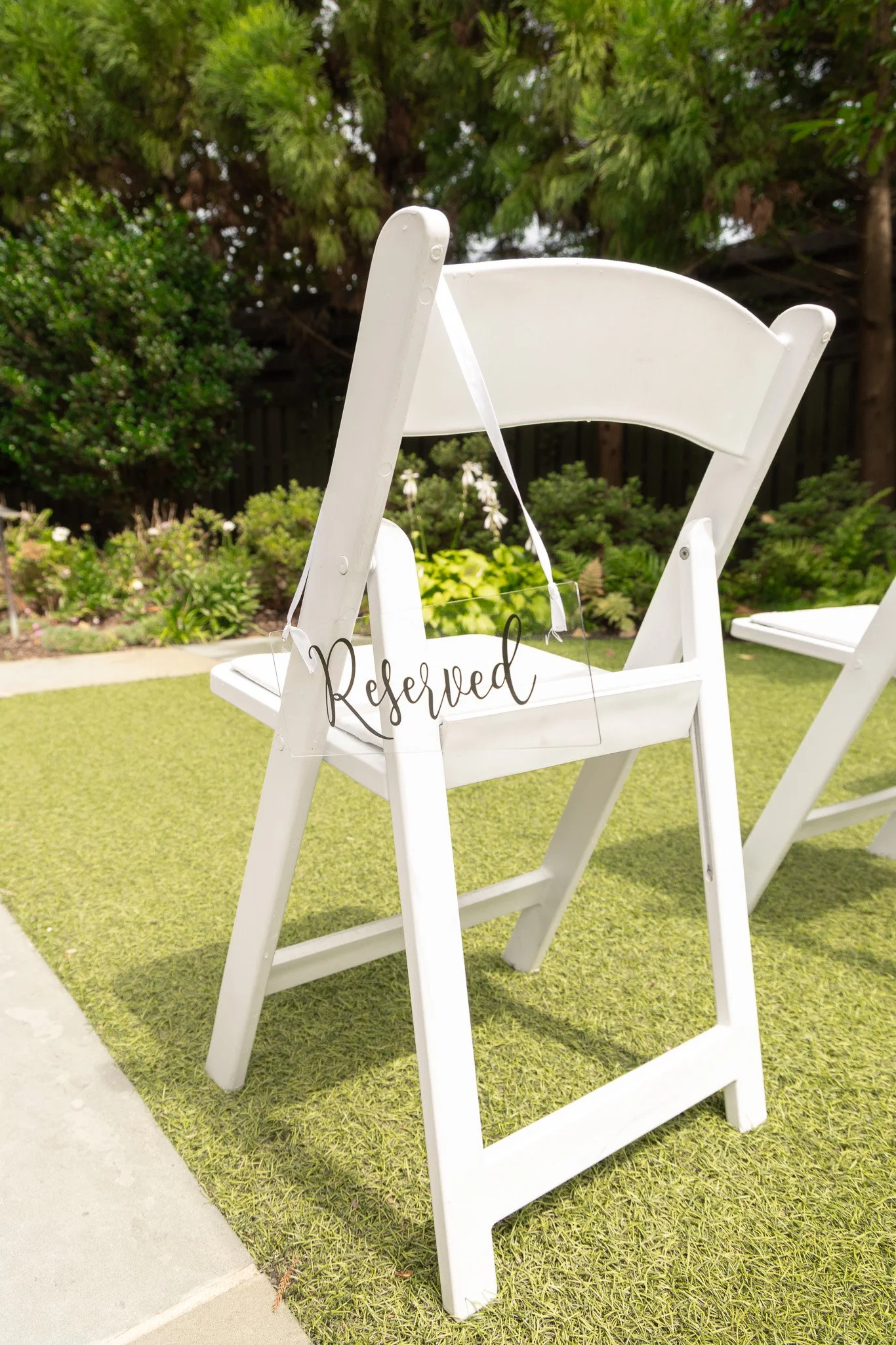 White wooden chairs outdoors, one with a 