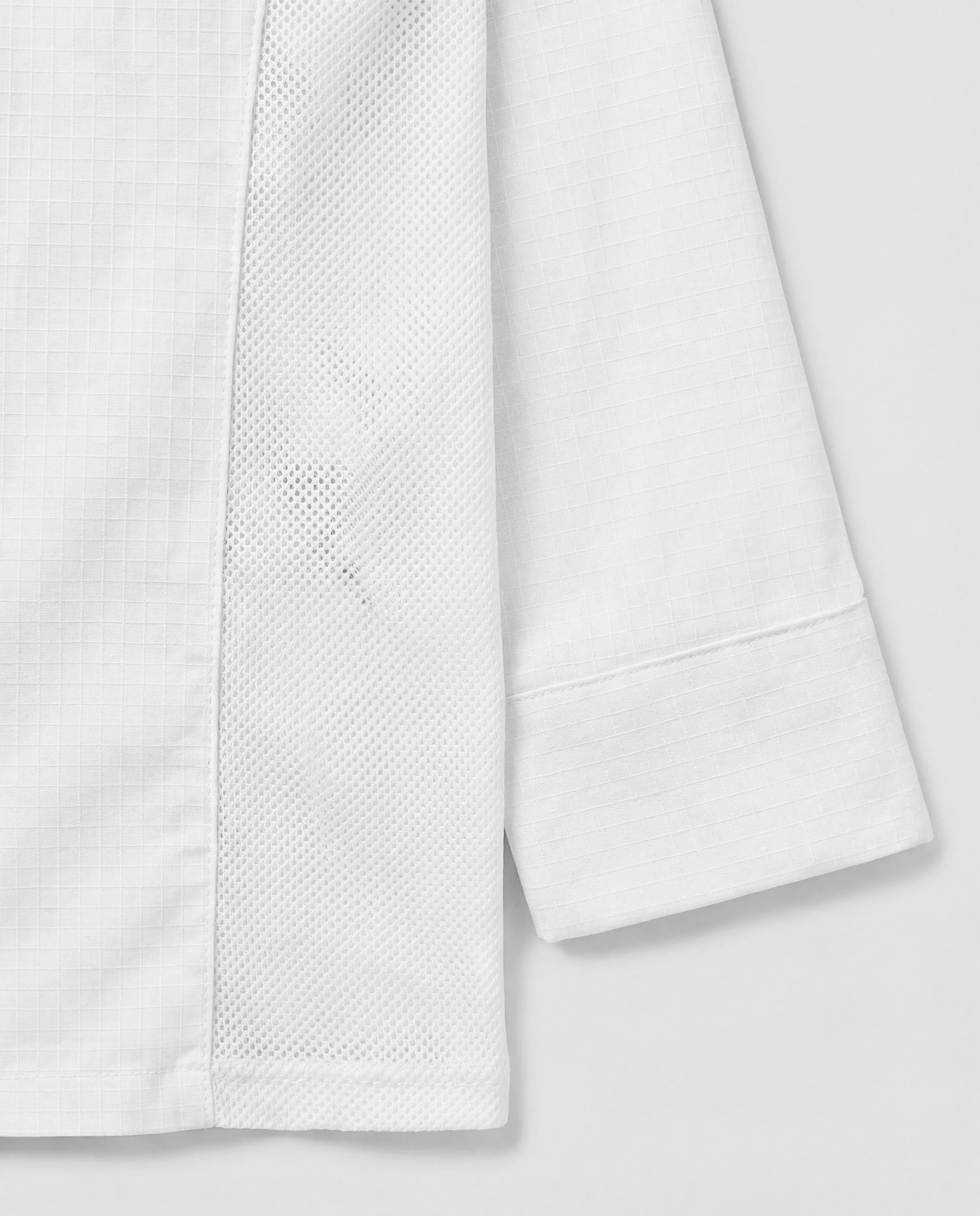 Close-up of the enhanced ventilation side mesh on the ChefShield™ Pro Chef Jacket, designed to keep air moving during hot kitchen service.