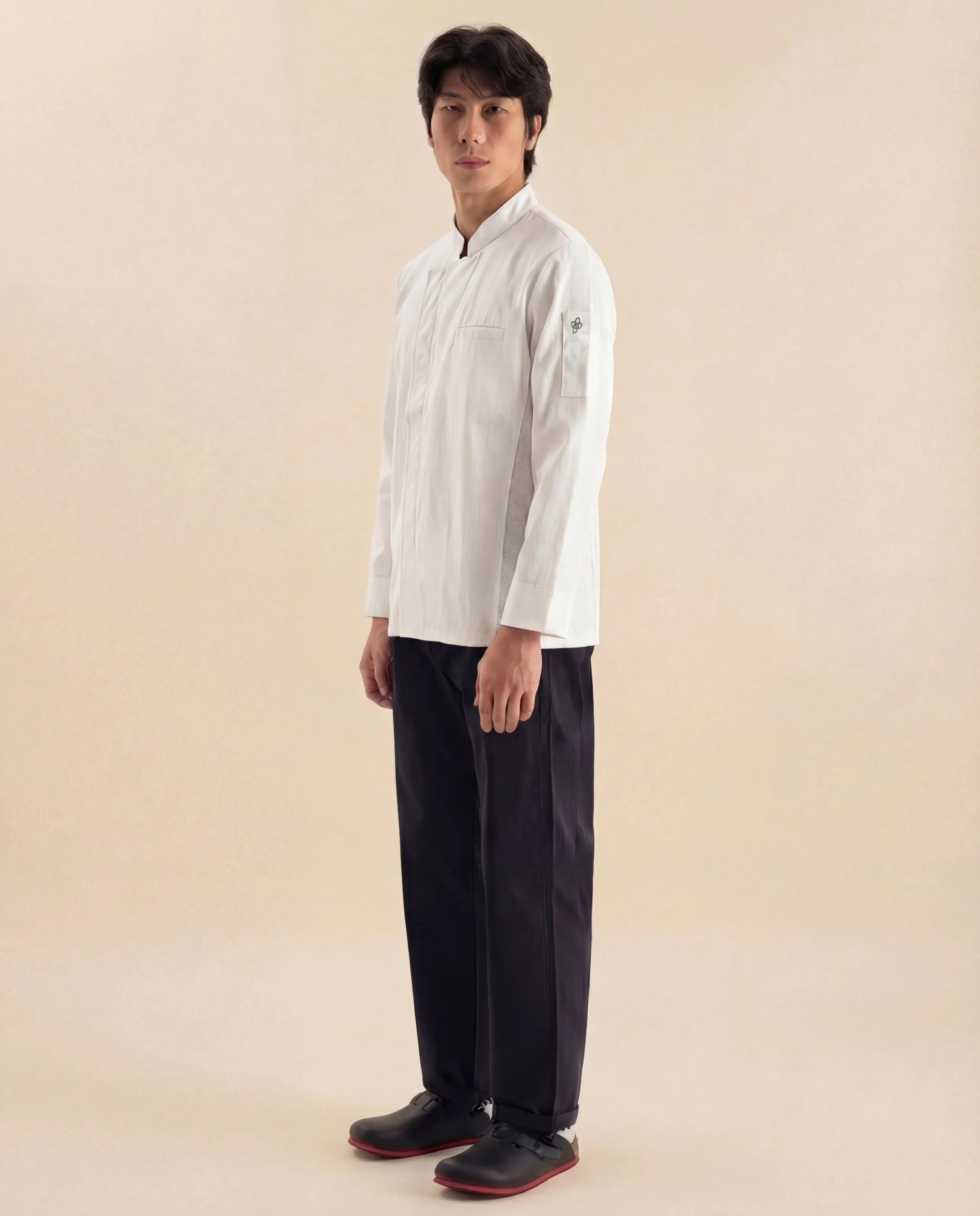 Chef wearing the ChefShield™ Pro Chef Jacket, showcasing its modern professional silhouette, ergonomic construction and functional kitchenwear design.