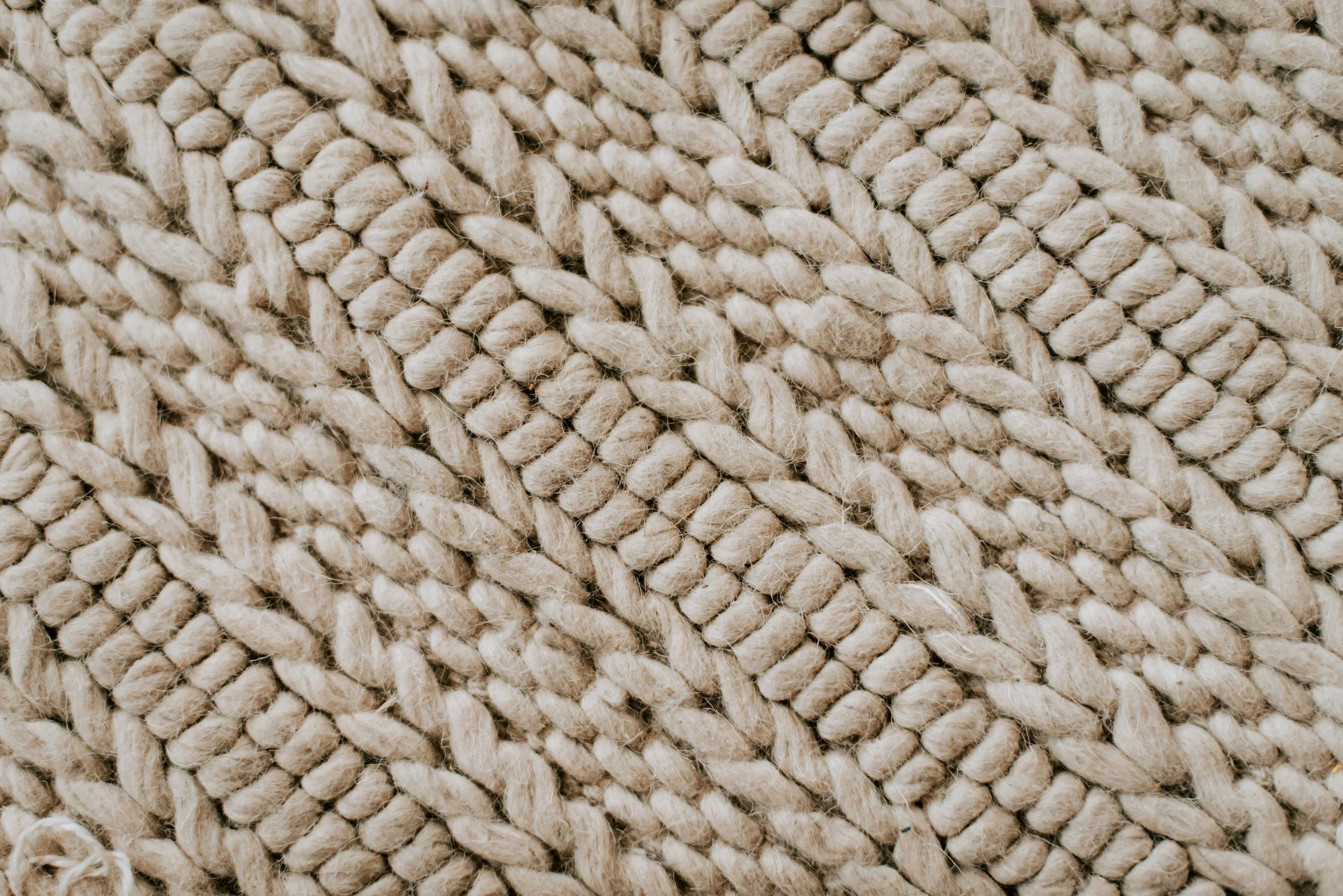 Close-up of beige, twisted rope fibers woven together.