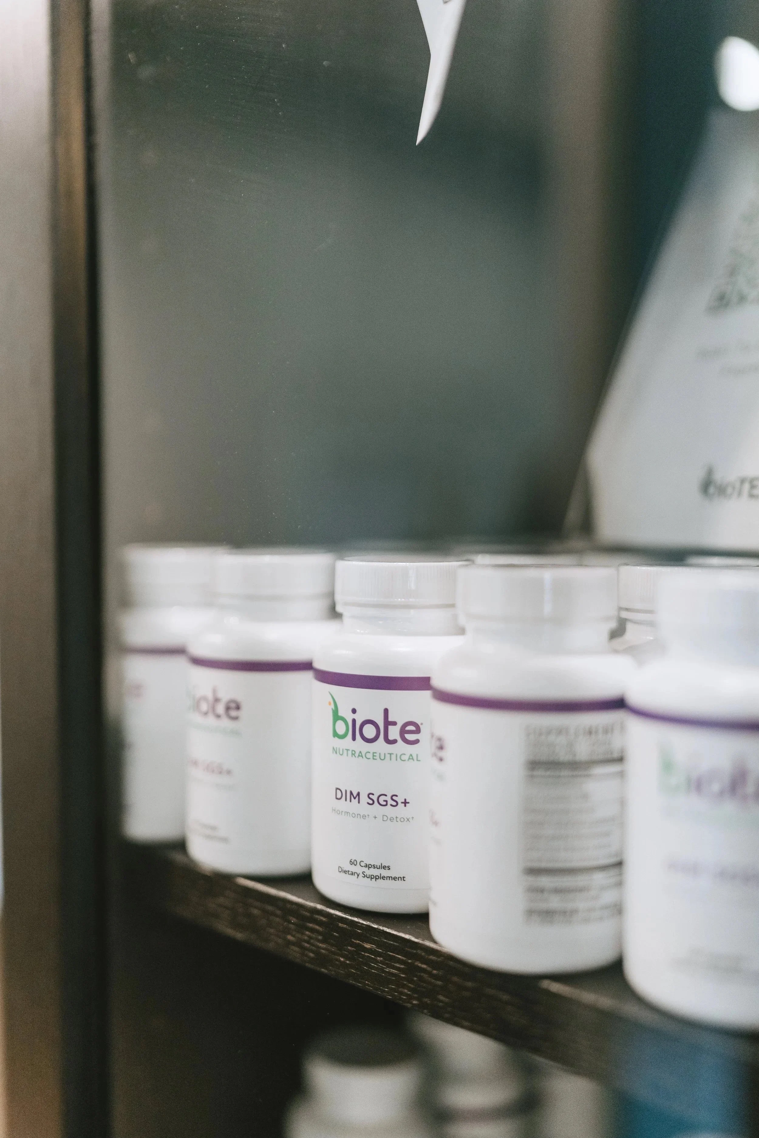 Bottle of Biote dietary supplement on a shelf in a pharmacy or store.