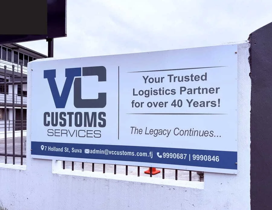 Sign for VC Customs Services, a logistics company, with contact details and a message about their 40 years of experience.