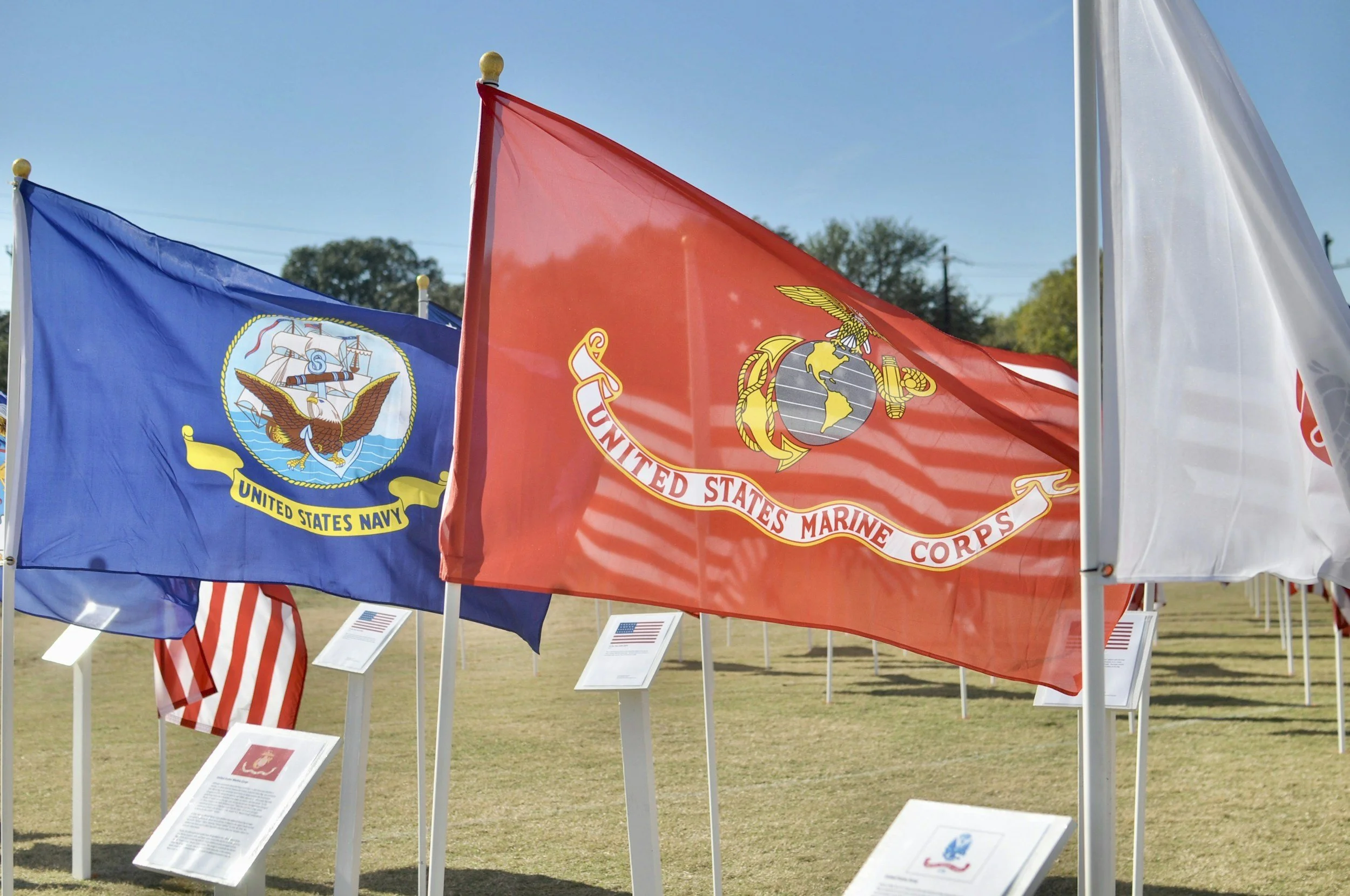 Flags of the United States Navy and Marine Corps displayed outdoors.