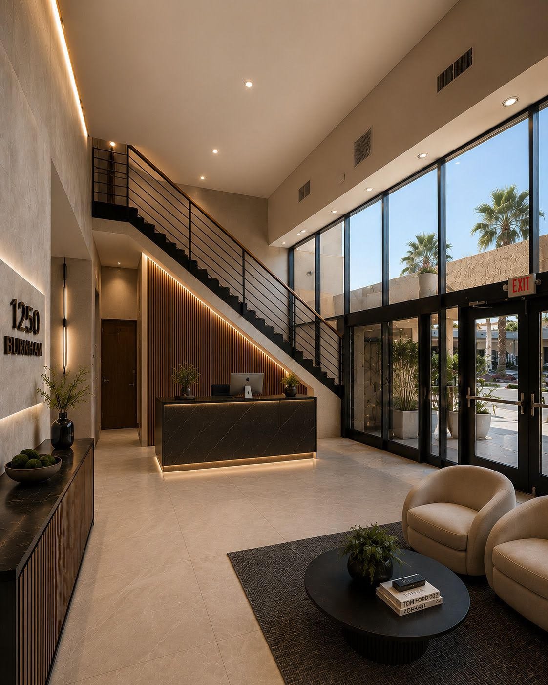 Modern hotel lobby interior featuring a reception desk, black marble counter, beige chairs, potted plants, glass entrance doors, and a staircase leading to an upper floor with large windows showing palm trees outside.