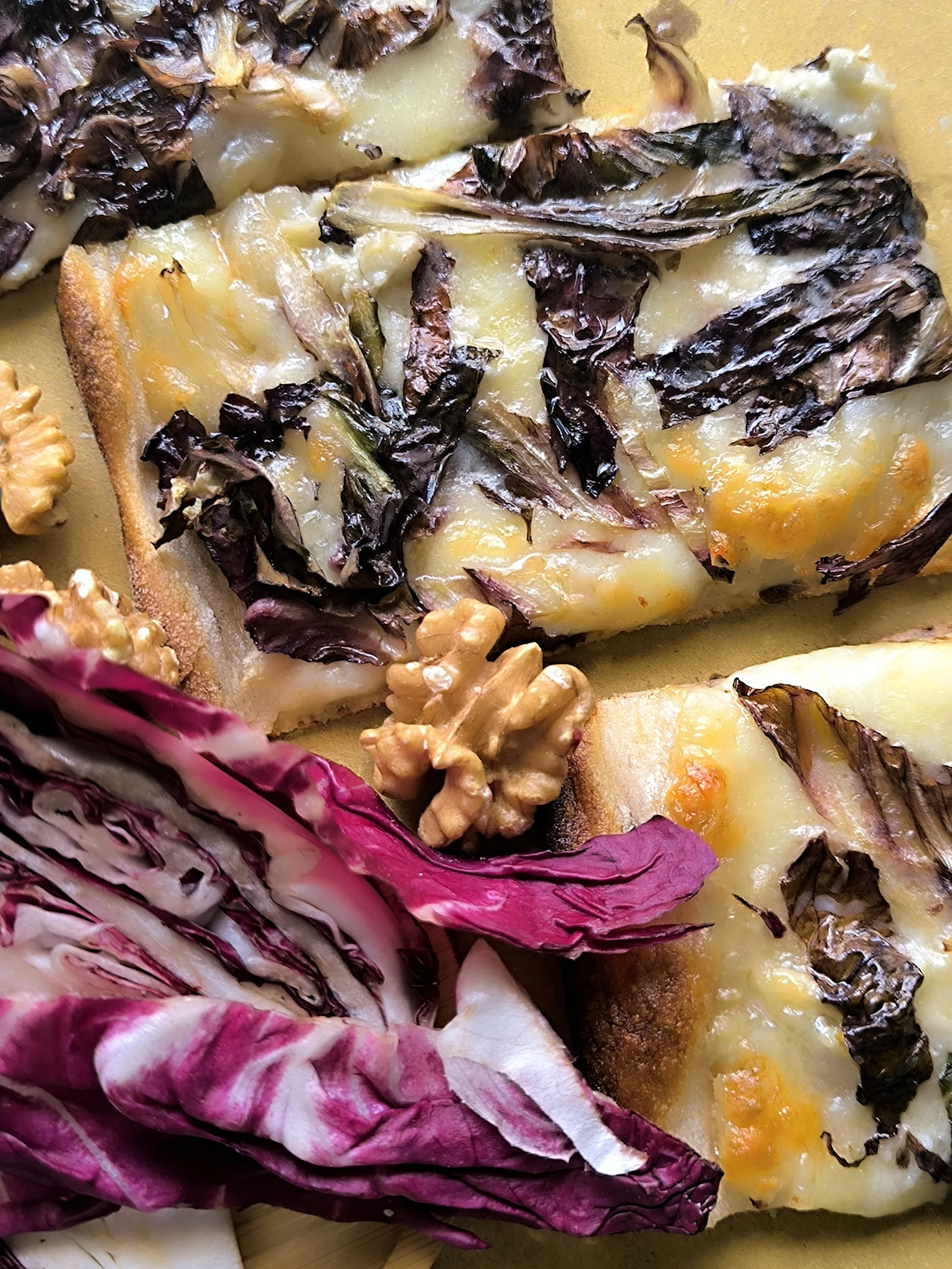 Fetta di pizza con formaggio,patate, zucca e foglie di radicchio.