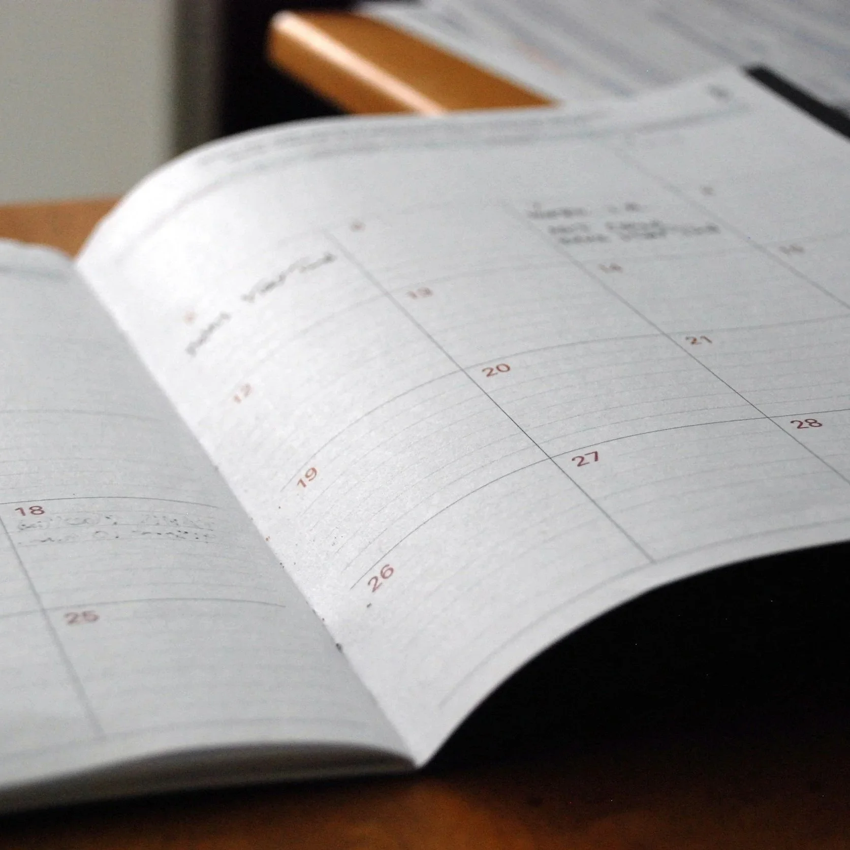 Close-up of an open calendar showing dates from the 18th to 26th, with blank spaces for writing.