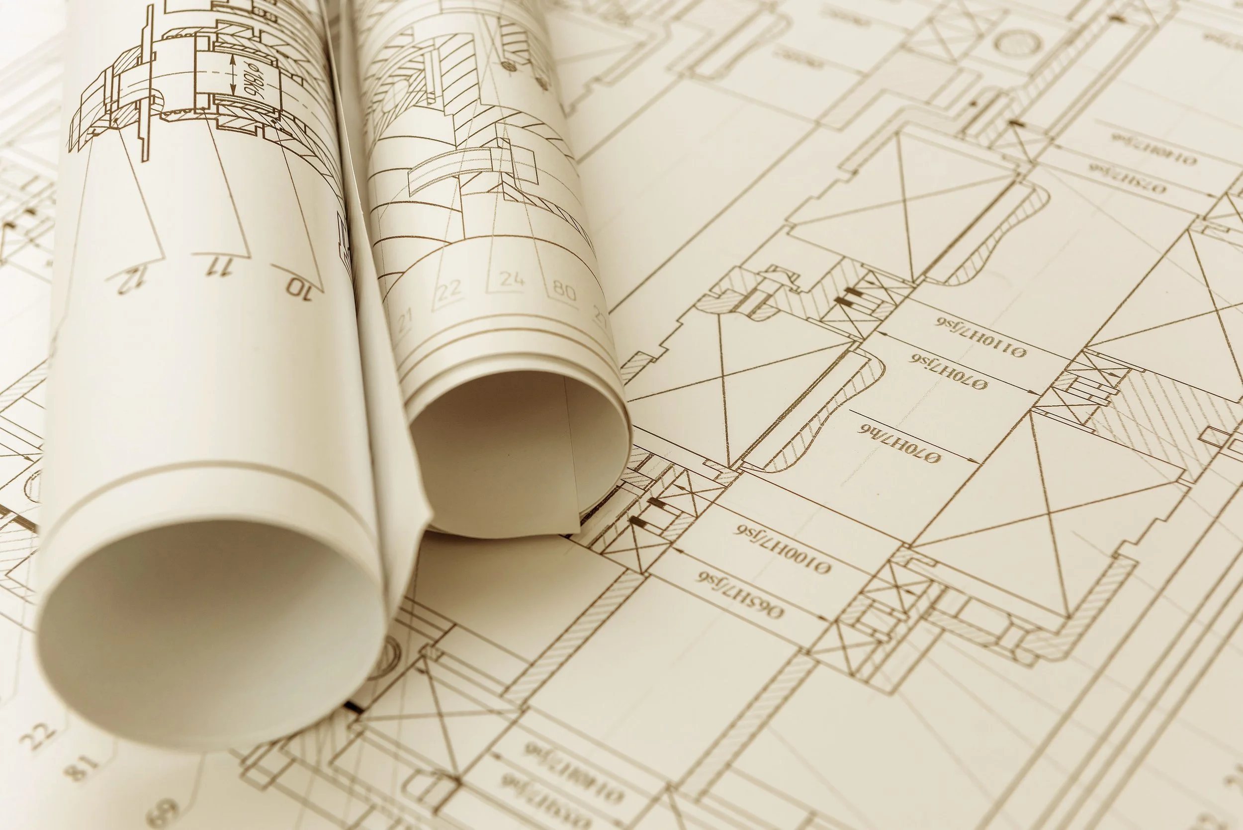 Architectural blueprints with rolled-up and laid-out floor plans.