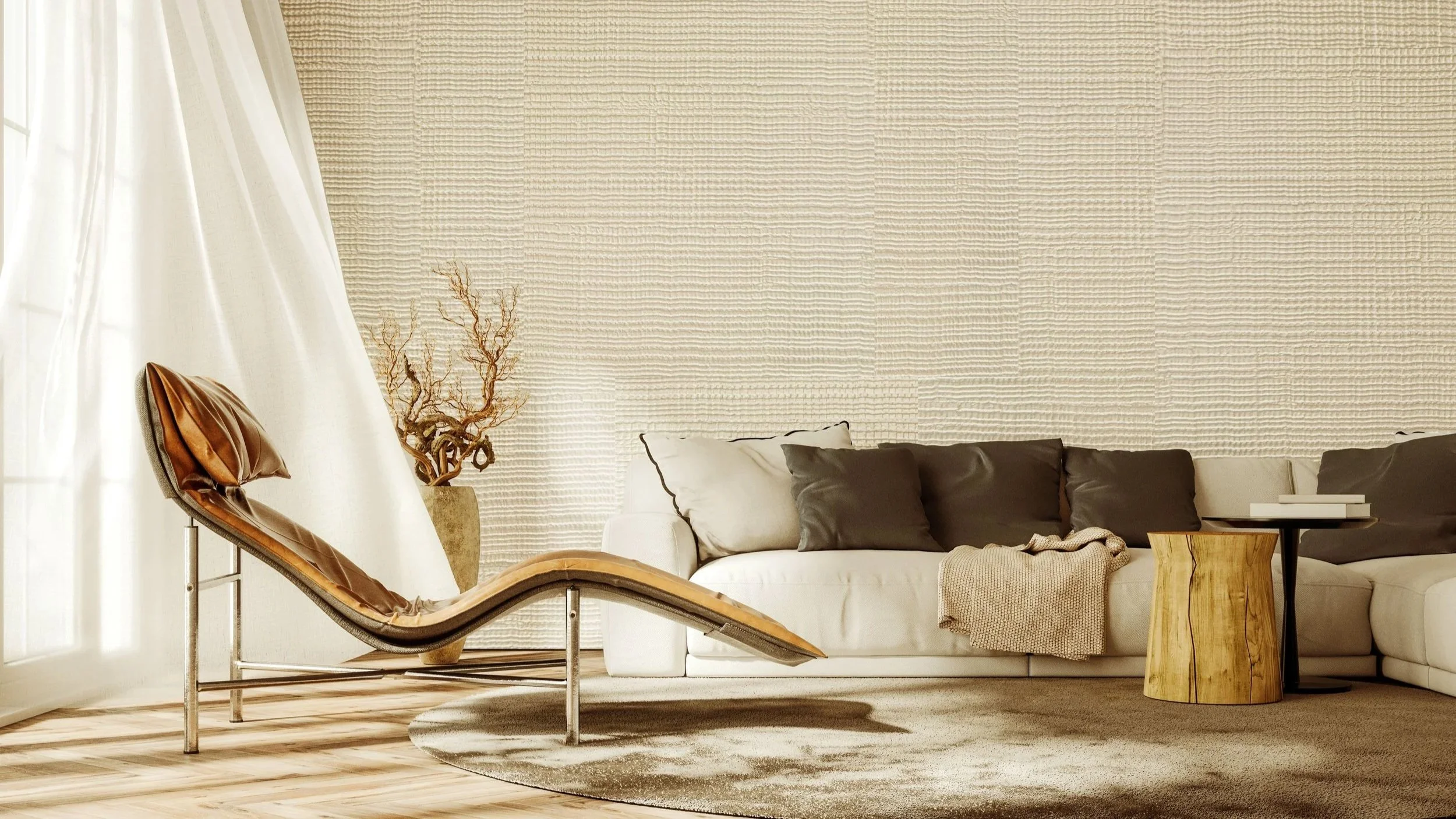Modern living room with beige textured wall, white sofa with black and beige pillows, a wooden side table, a reclining chair with leather cushions, a decorative branch in a vase, and a round beige rug on wooden flooring.