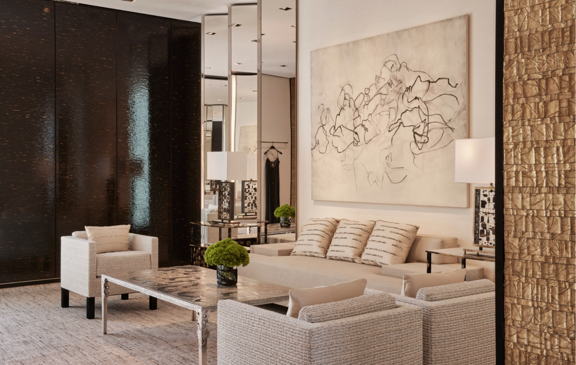 Modern hotel lobby with cream sofa and armchairs, black patterned coffee table, large abstract line art on the wall, black textured sliding doors, potted green plants, and gold textured wall accents.