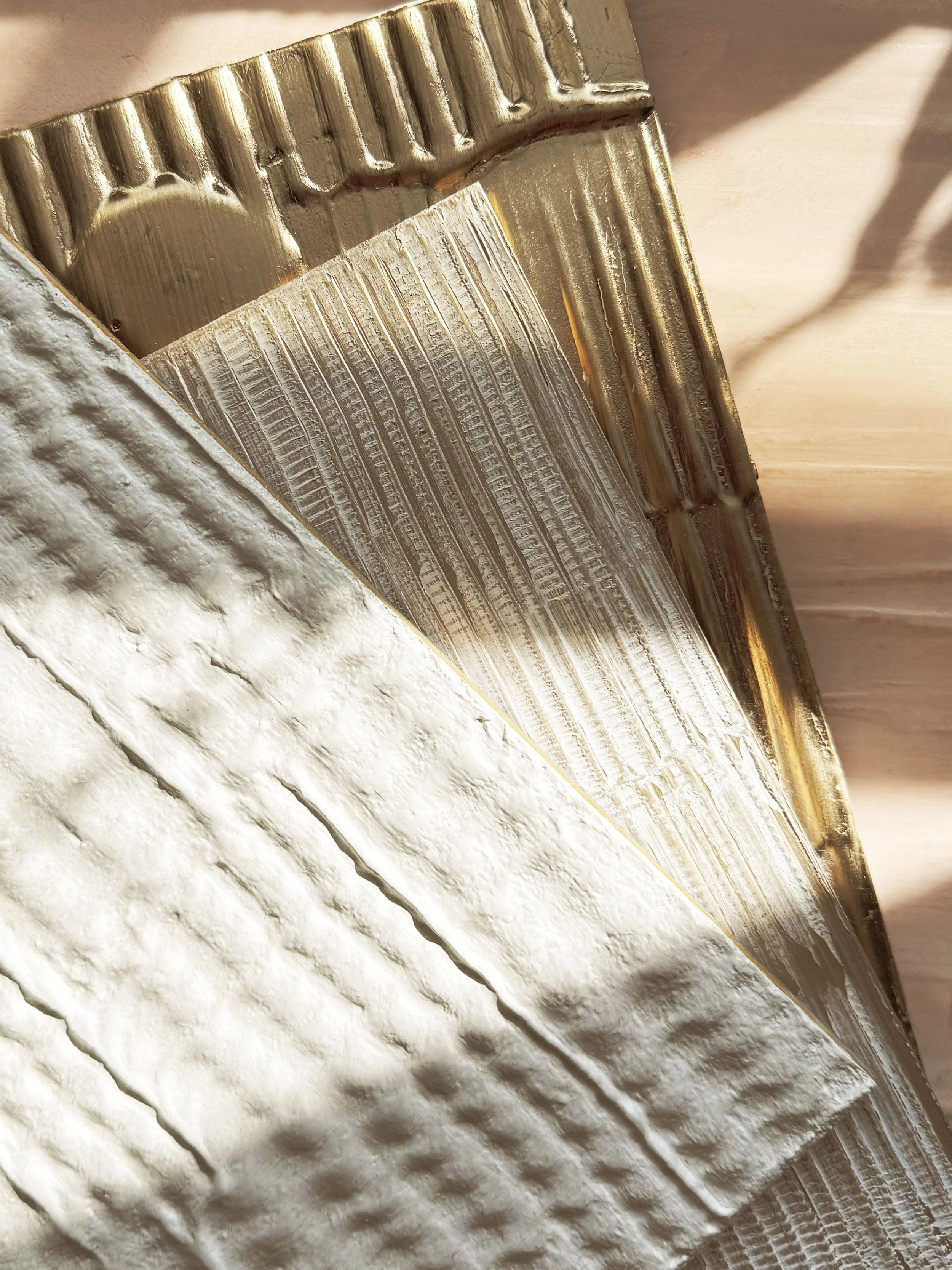 Close-up of a textured and layered architectural ceiling with metallic trim and decorative molding.