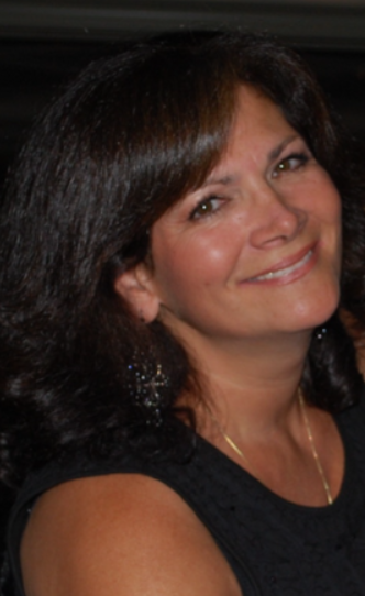 A smiling woman with dark hair, wearing earrings and a black top.