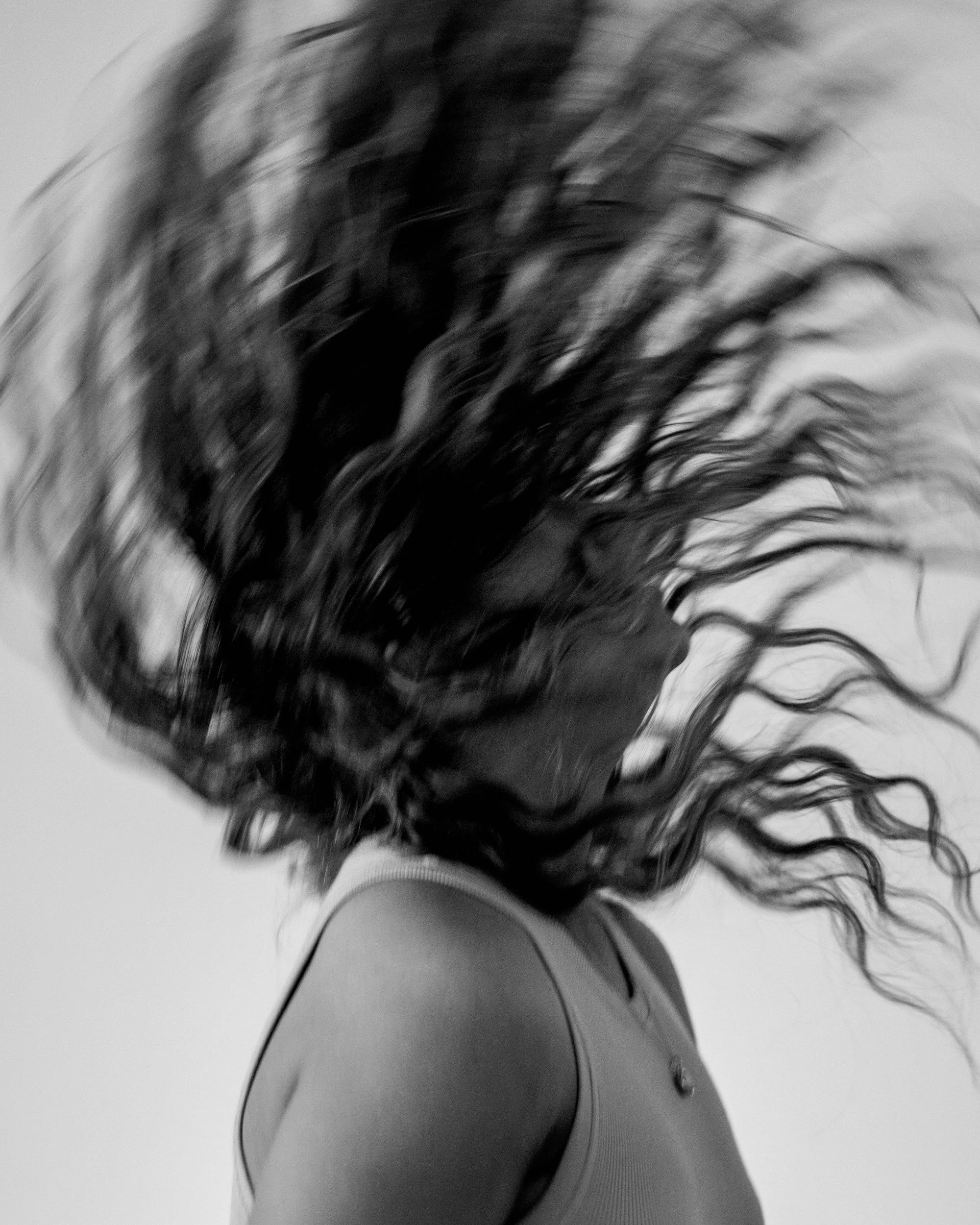 A photo of woman flipping curly hair.
