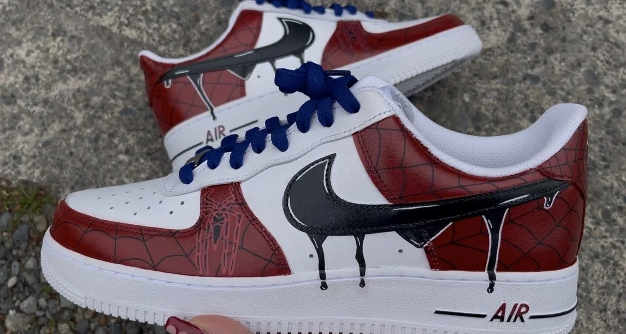 Close-up of custom Spider-Man Air Force 1 with hand-painted dripping swoosh and web pattern artwork.