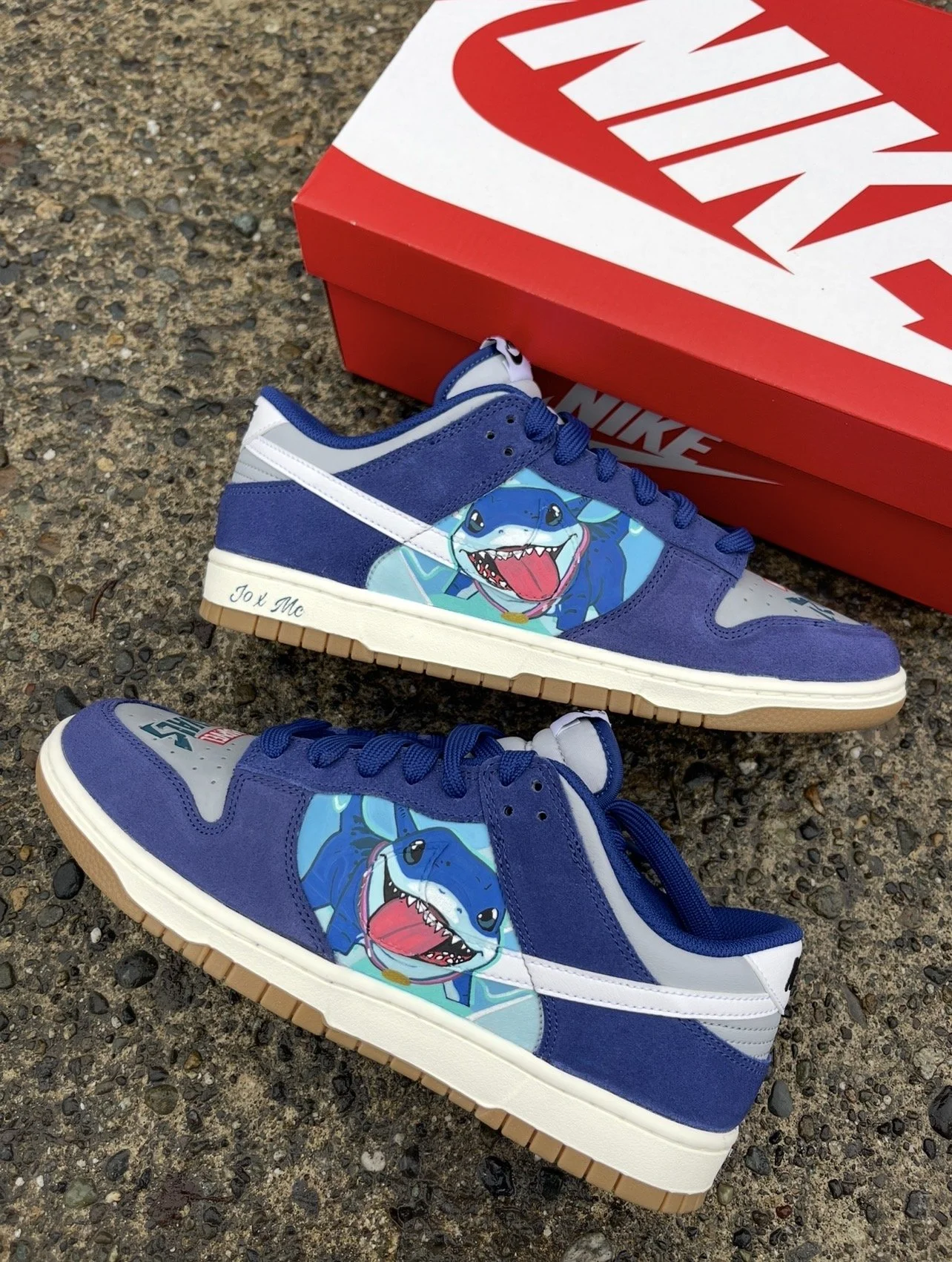 Pair of hand-painted Nike Dunks featuring Jeff the Land Shark artwork displayed beside a Nike shoe box.