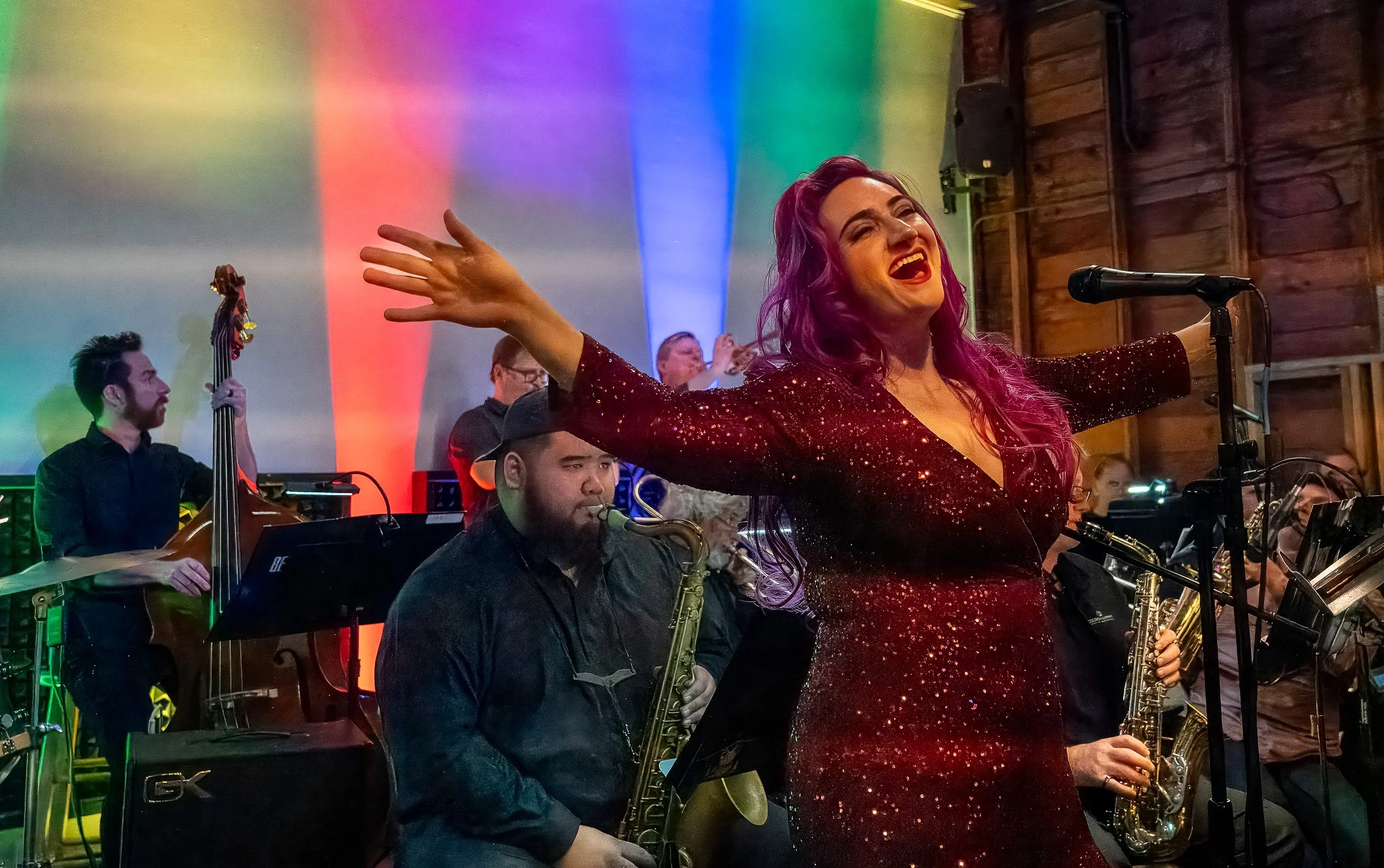 A female singer from Stages Theatre performing with the Jazz Collective Big Band at a dance concert at The Ruins