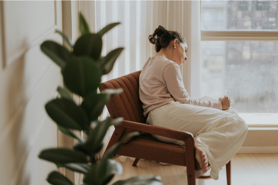 Woman sitting by a window, reflecting quietly