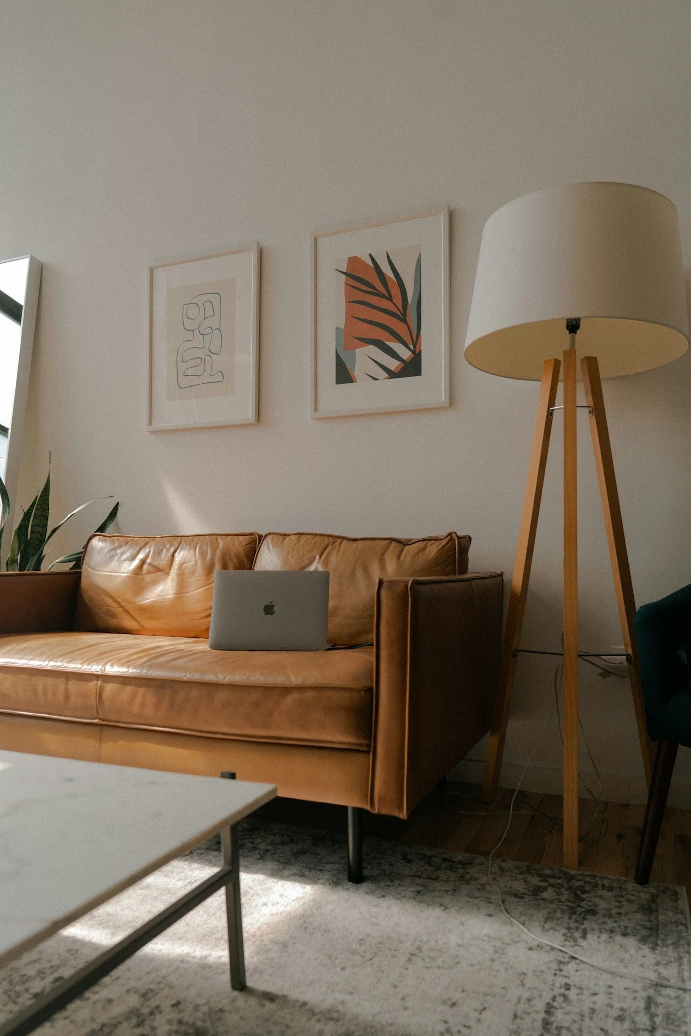 Warm, inviting living room with a tan leather couch and soft natural light