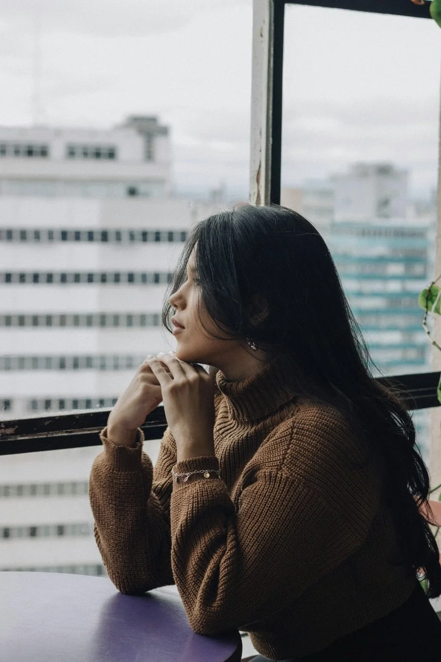 Woman looking out a window, lost in thought