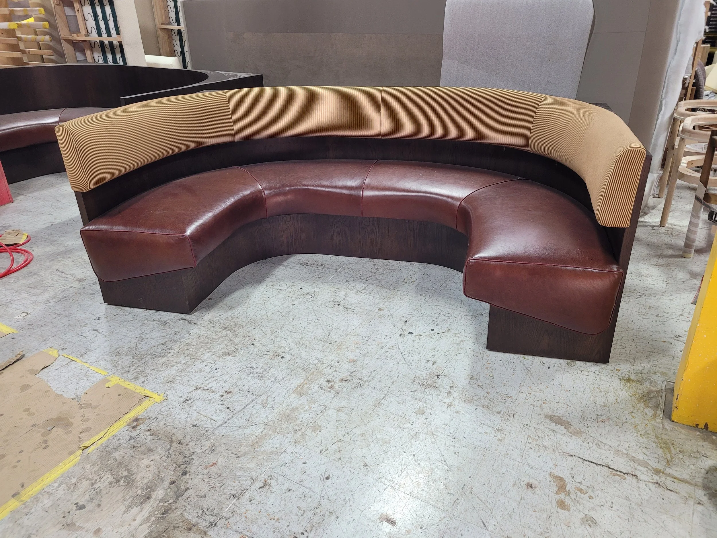 curved, two-tone sectional bench sofa with brown leather and a dark wood frame..jpg