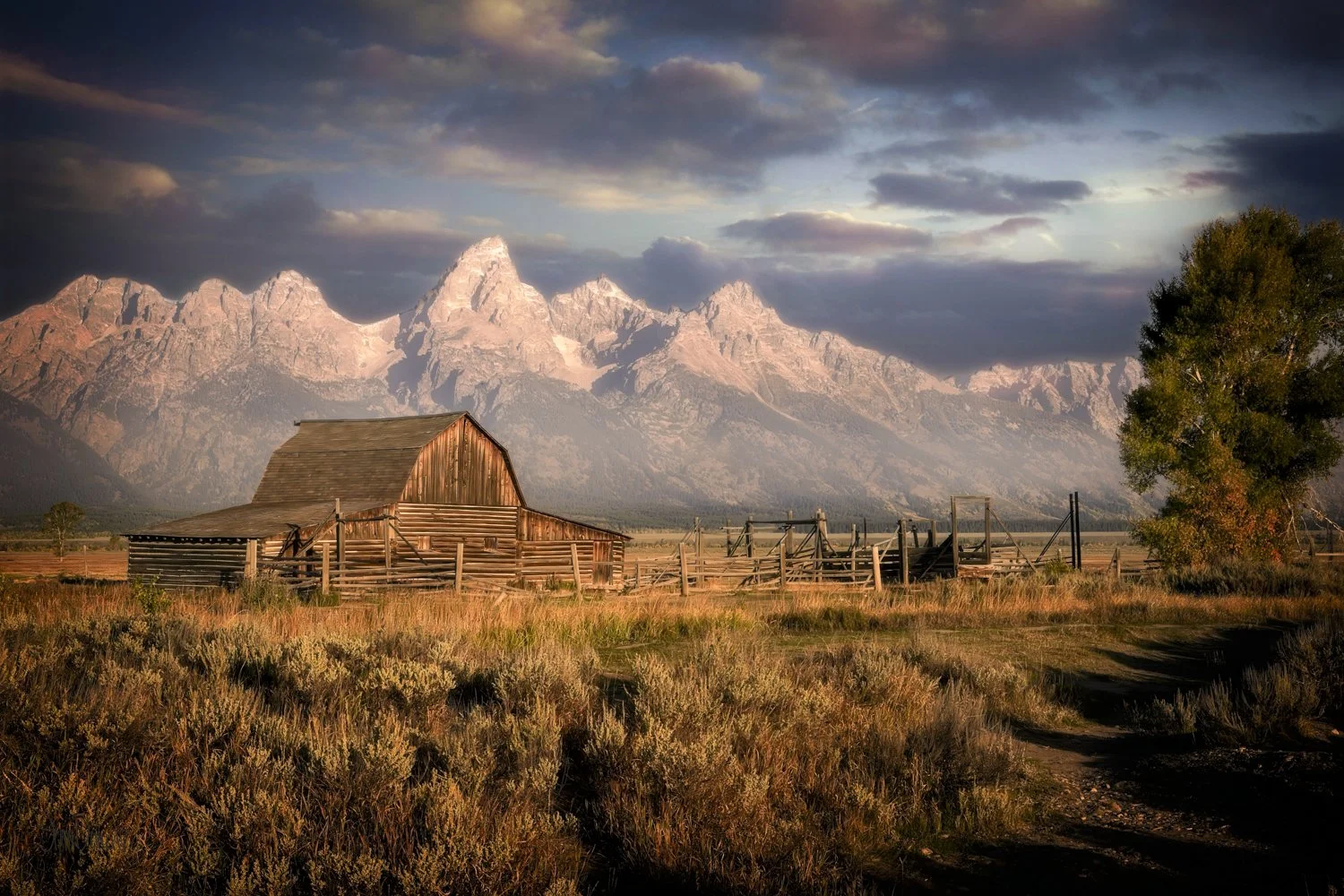 Moulton barn and the Teton Mountains at sunrise under a colorful cloudy sky
