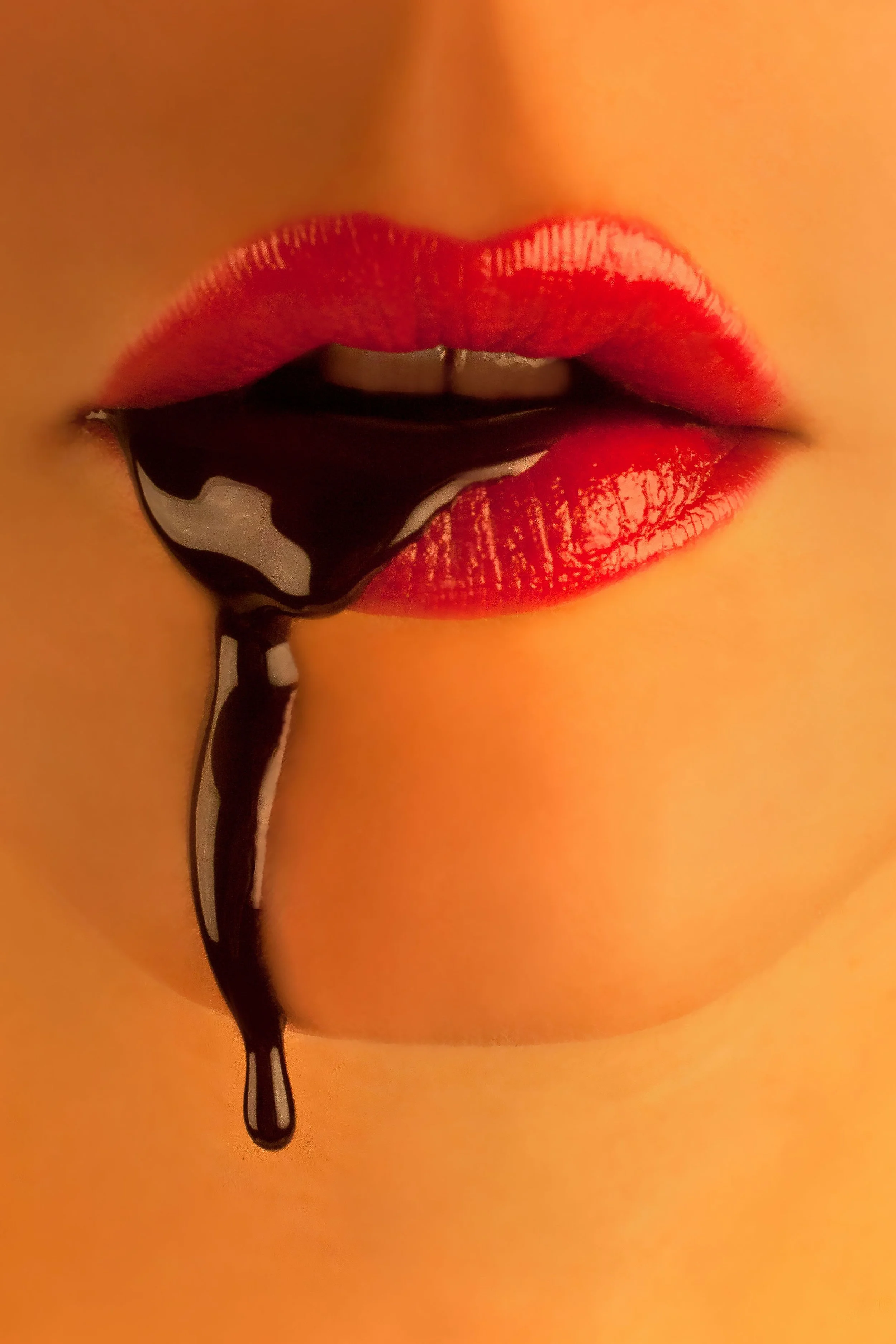 Close-up of face and glossy red lips wearing red lipstick with chocolate sauce dripping down lips and chin 