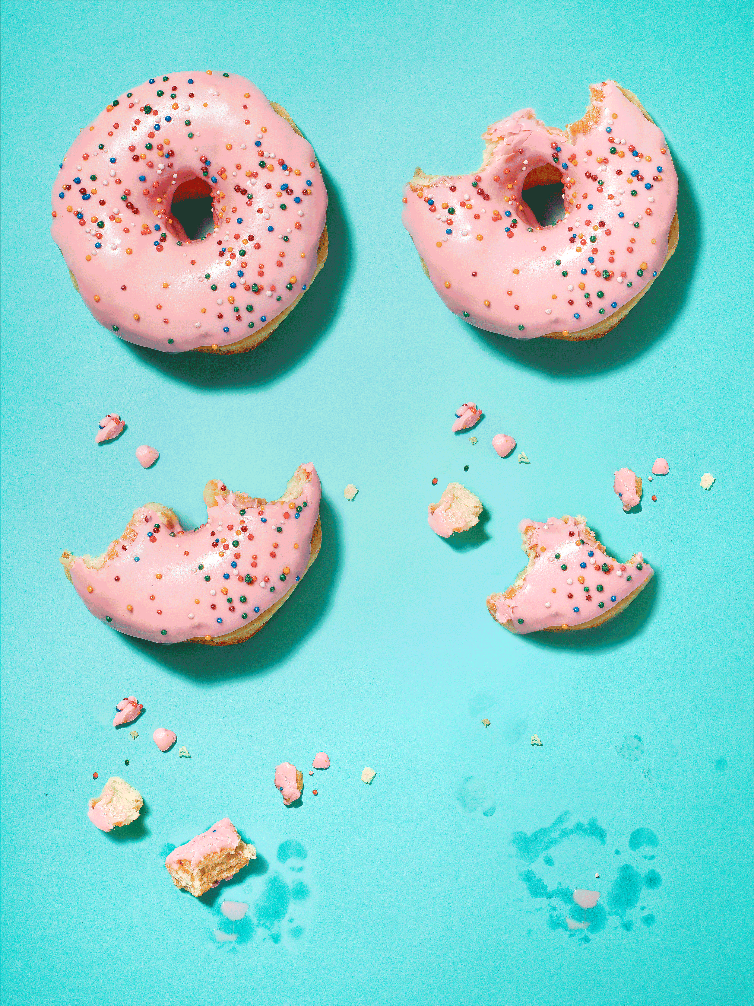 Sequence of Pink-frosted sprinkle donuts, including whole and partially eaten donuts, on a turquoise background