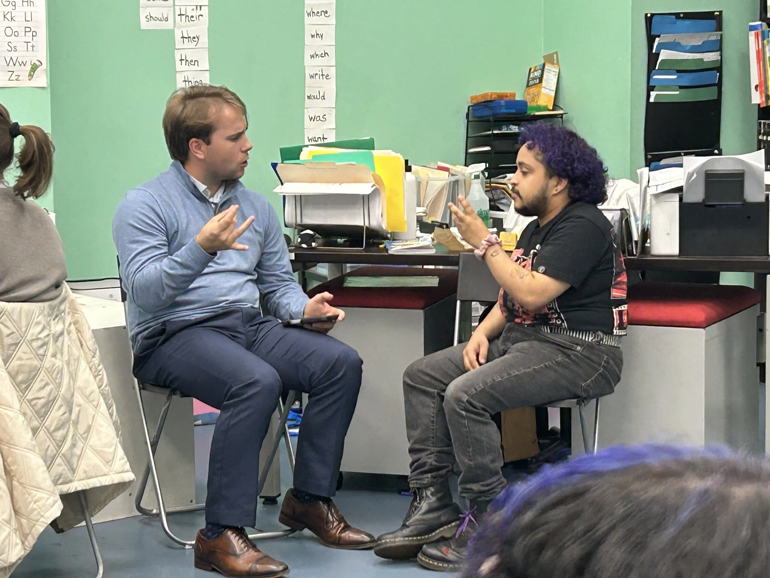 Two students practicing ASL in a classroom.