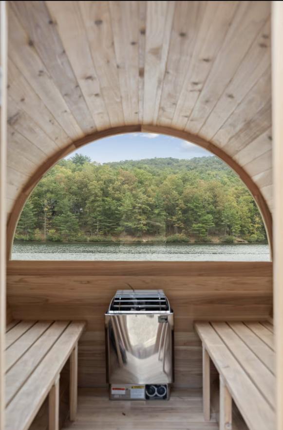 "Panoramic view of Lake Laura and mountains through the window of a private lakeside sauna at Exhale Getaways."