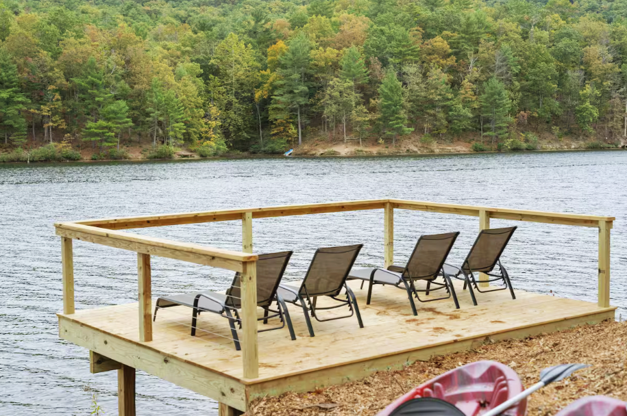 A wooden deck with beach chairs looking out into Lake Laura and the Shenandoah Valley Mountains