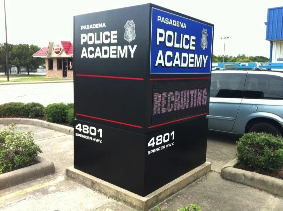 Sign for Pasadena Police Academy with an electronic display, located at 4801 Spencer Highway, showing the word 'RECRUITING'.