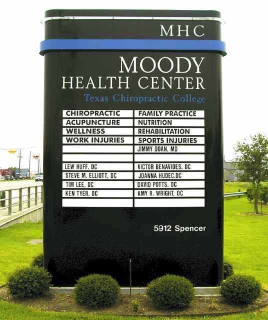 External signboard for Moody Health Center at Texas Chiropractic College with list of healthcare services and providers.