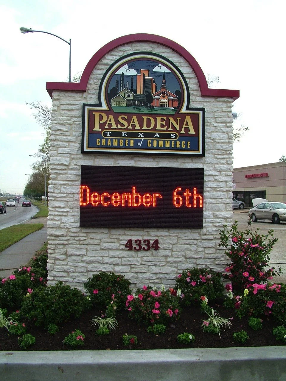 Sign for Pasadena, Texas, Chamber of Commerce displaying the date December 6th, with a colorful cityscape illustration at the top